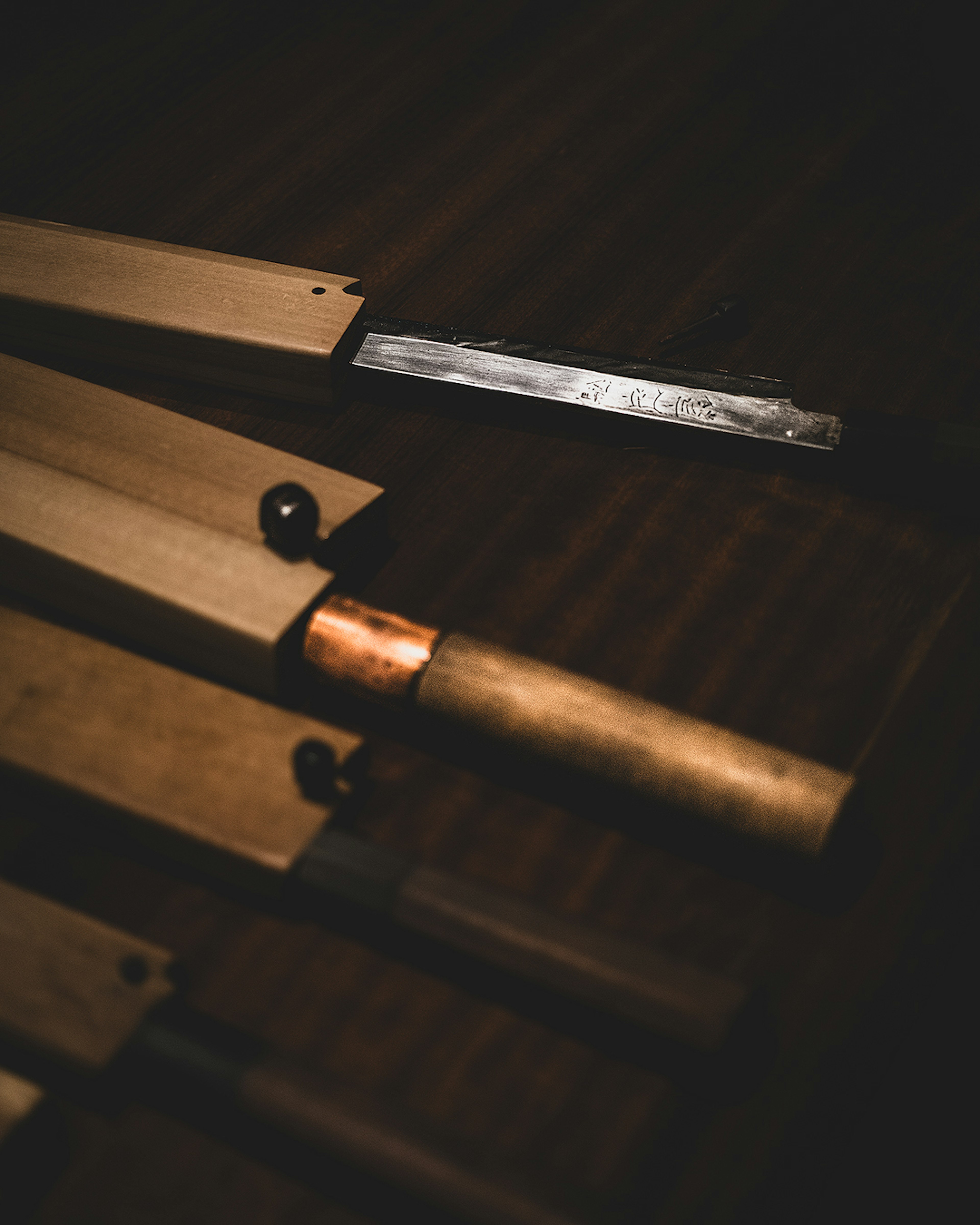 Image of wooden tools and metal parts arranged against a dark background