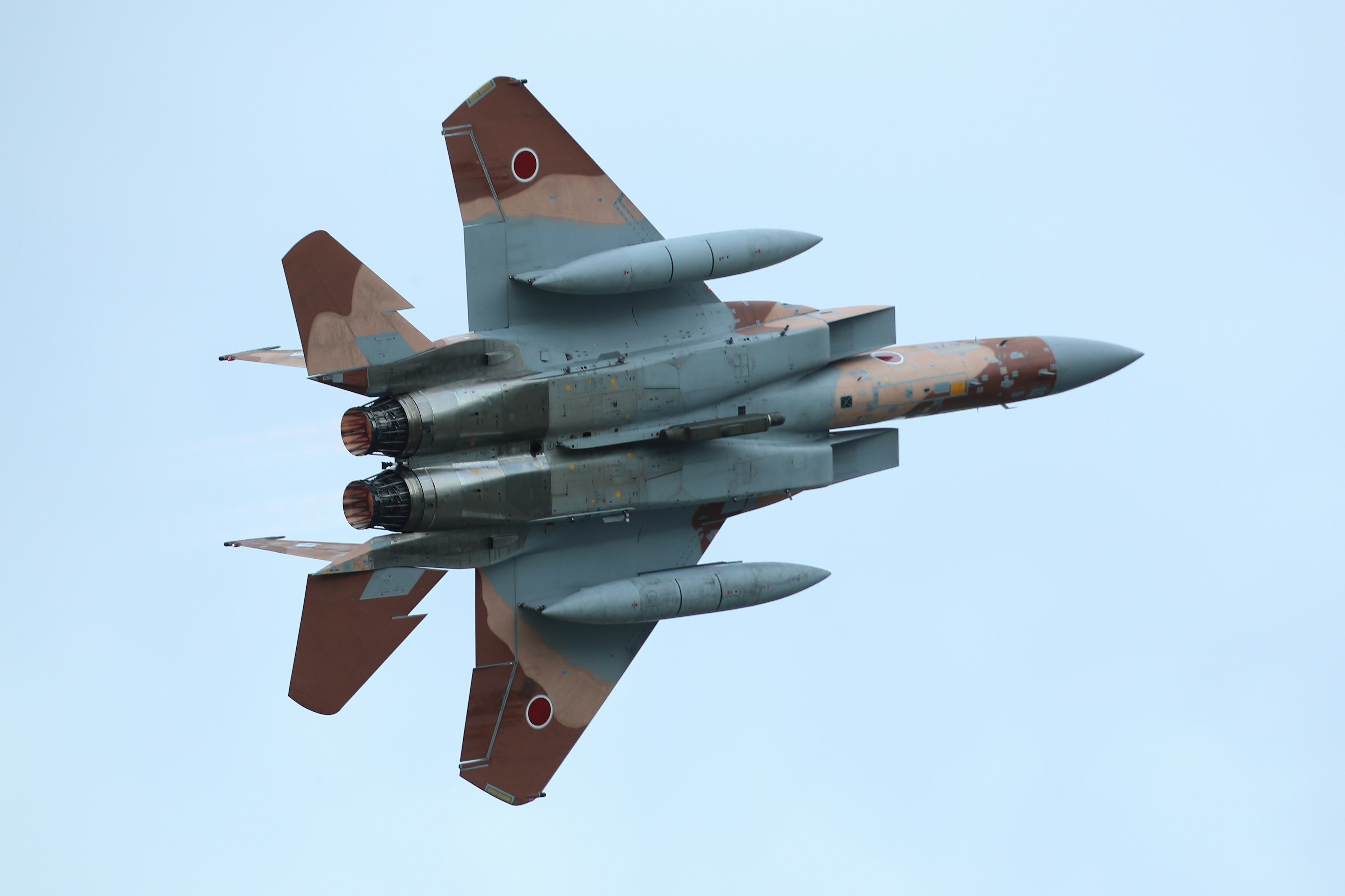 A fighter jet flying in the sky with a blue background