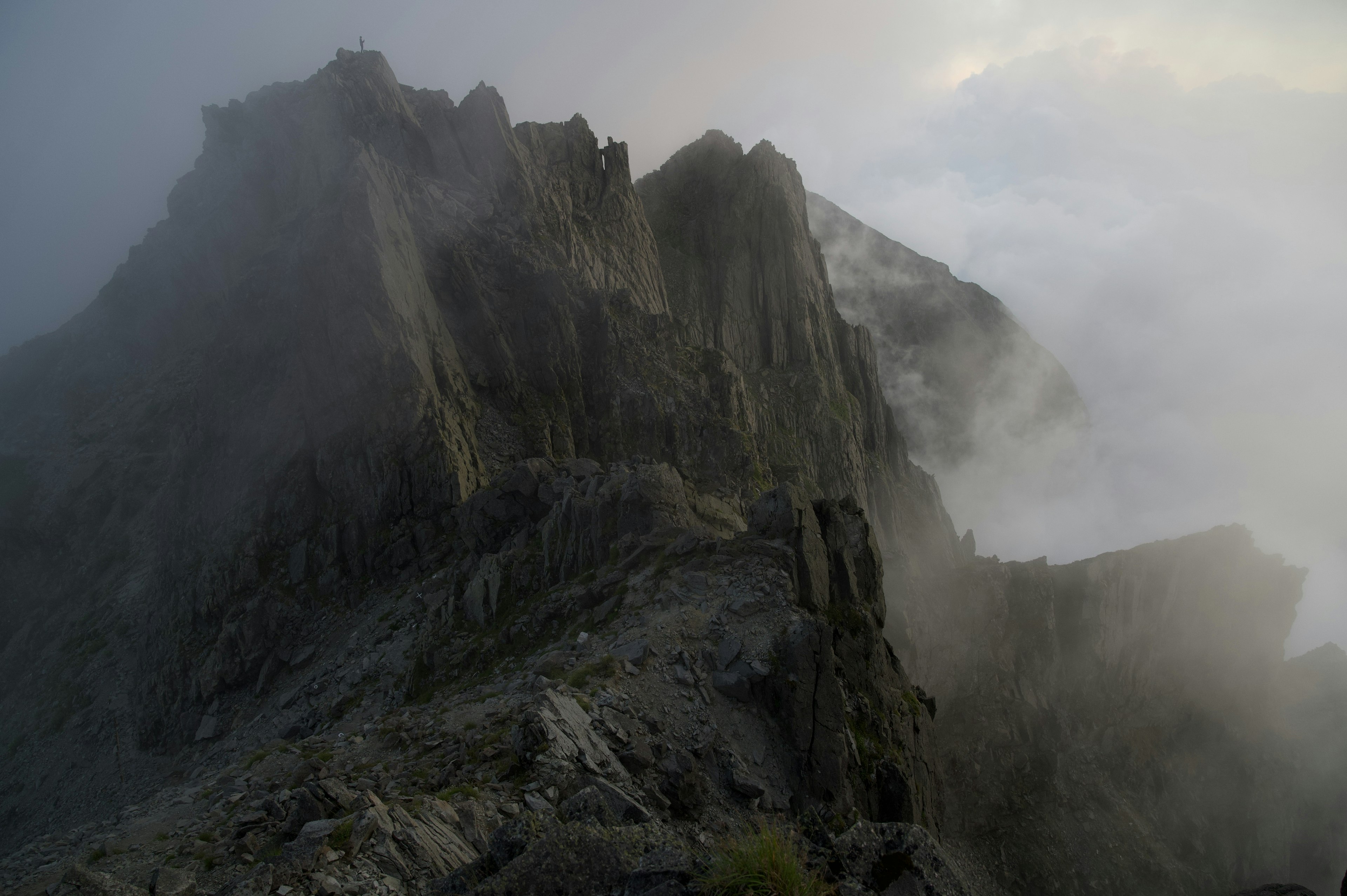 Jagged mountain peaks shrouded in mist with rocky terrain