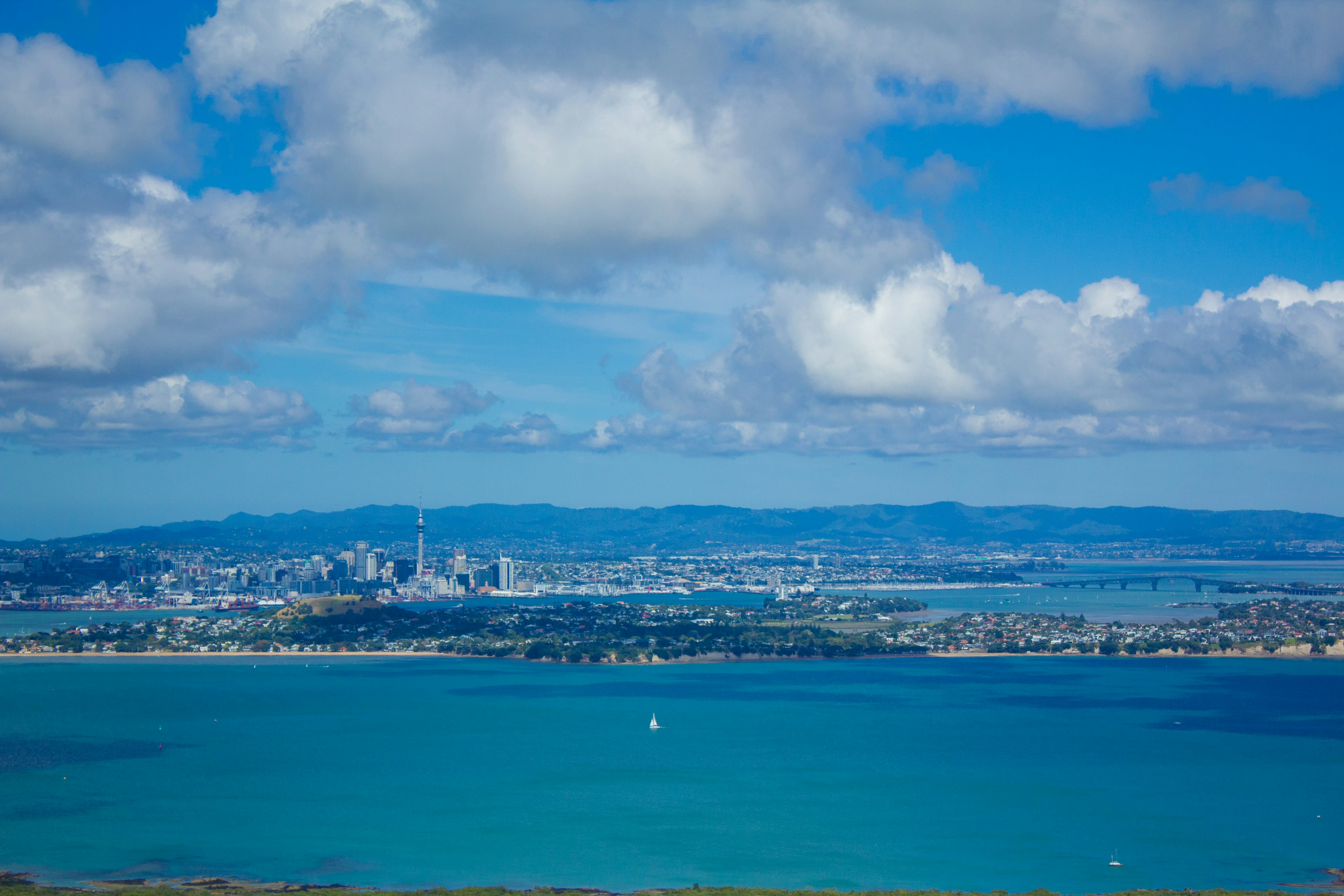 Vista panoramica di uno skyline urbano su acque turchesi sotto un cielo azzurro