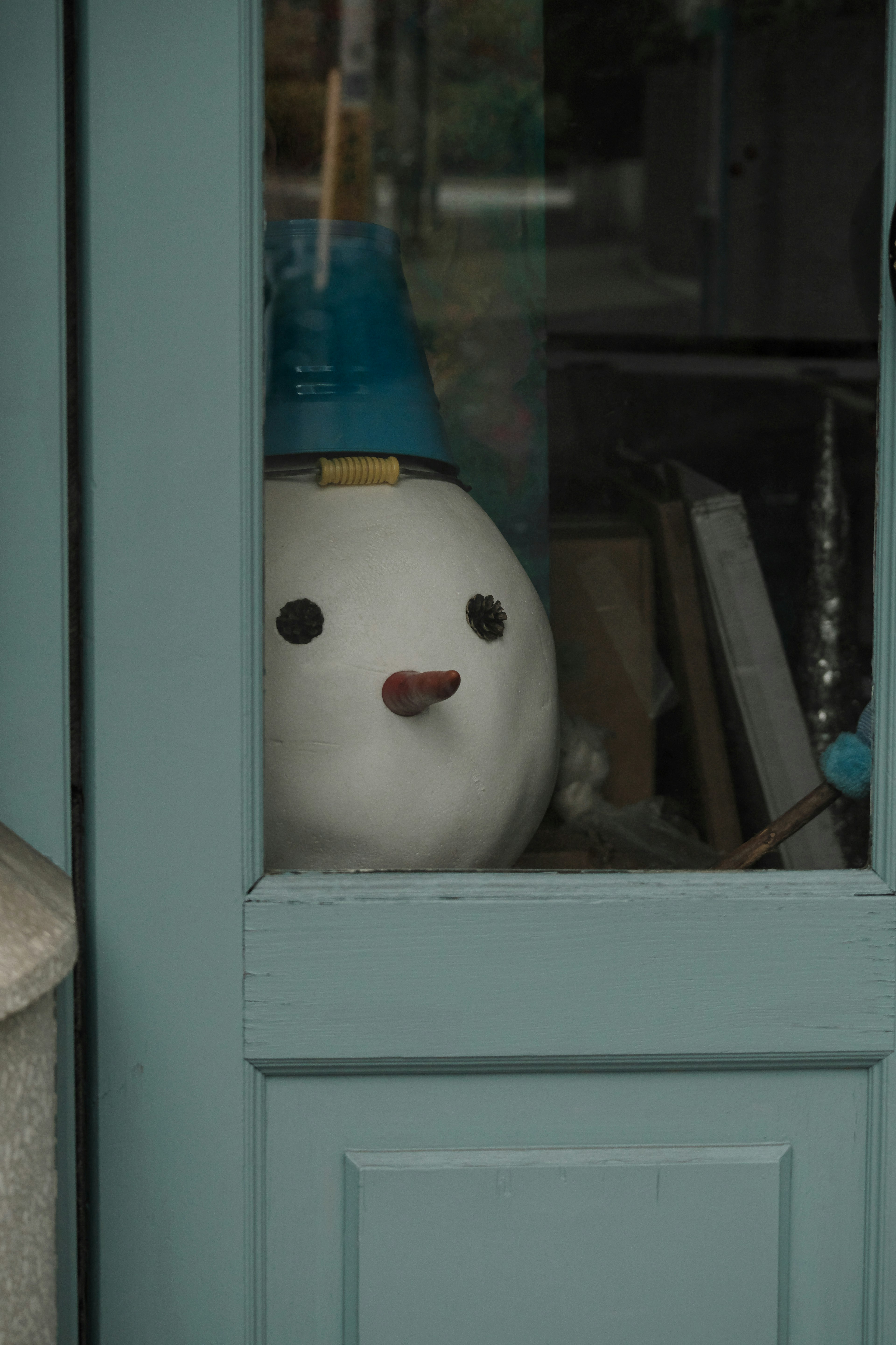 A white character wearing a blue hat is seen through a window