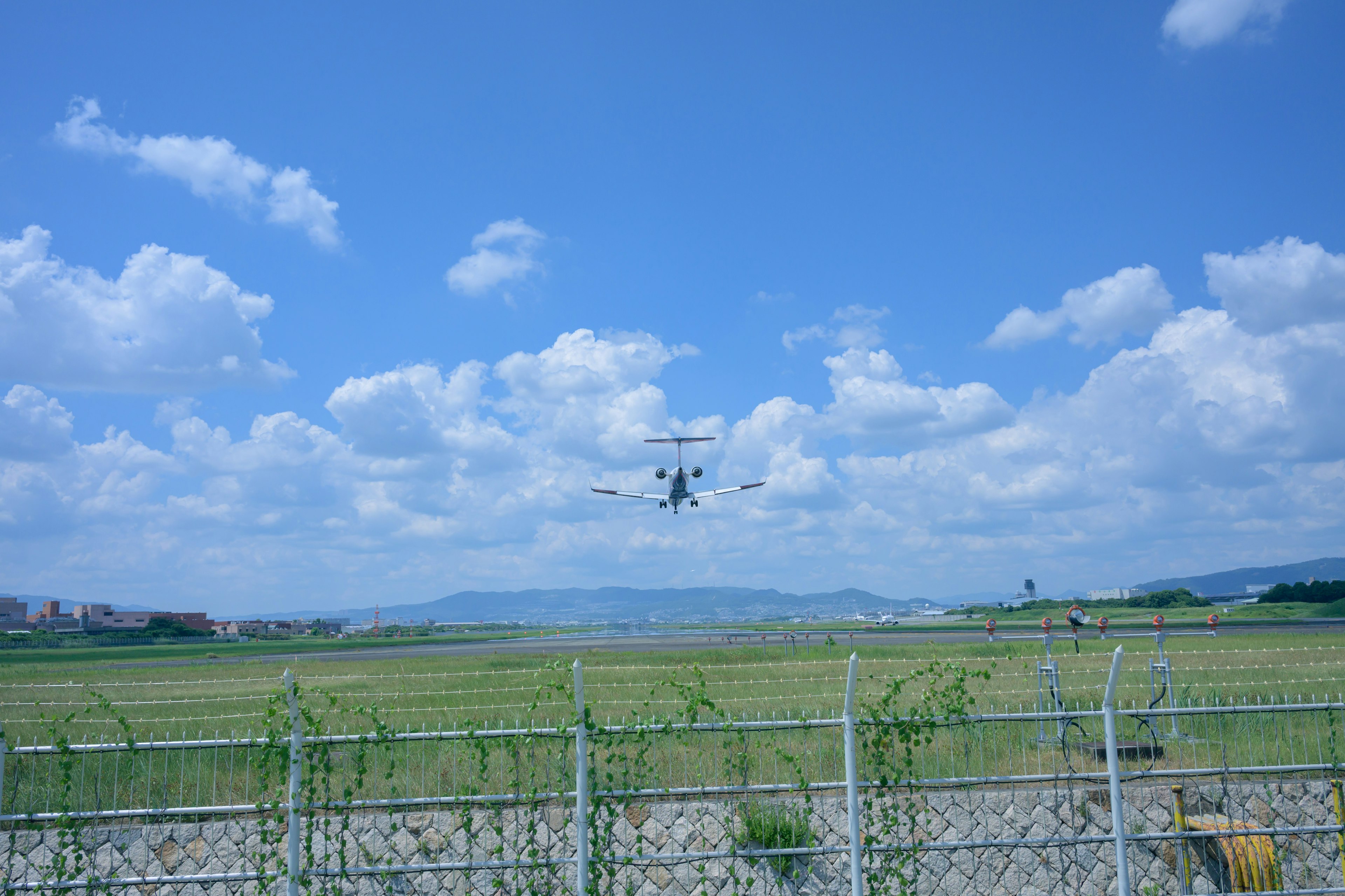 Ein Flugzeug startet an einem Flughafen unter einem klaren blauen Himmel und weißen Wolken