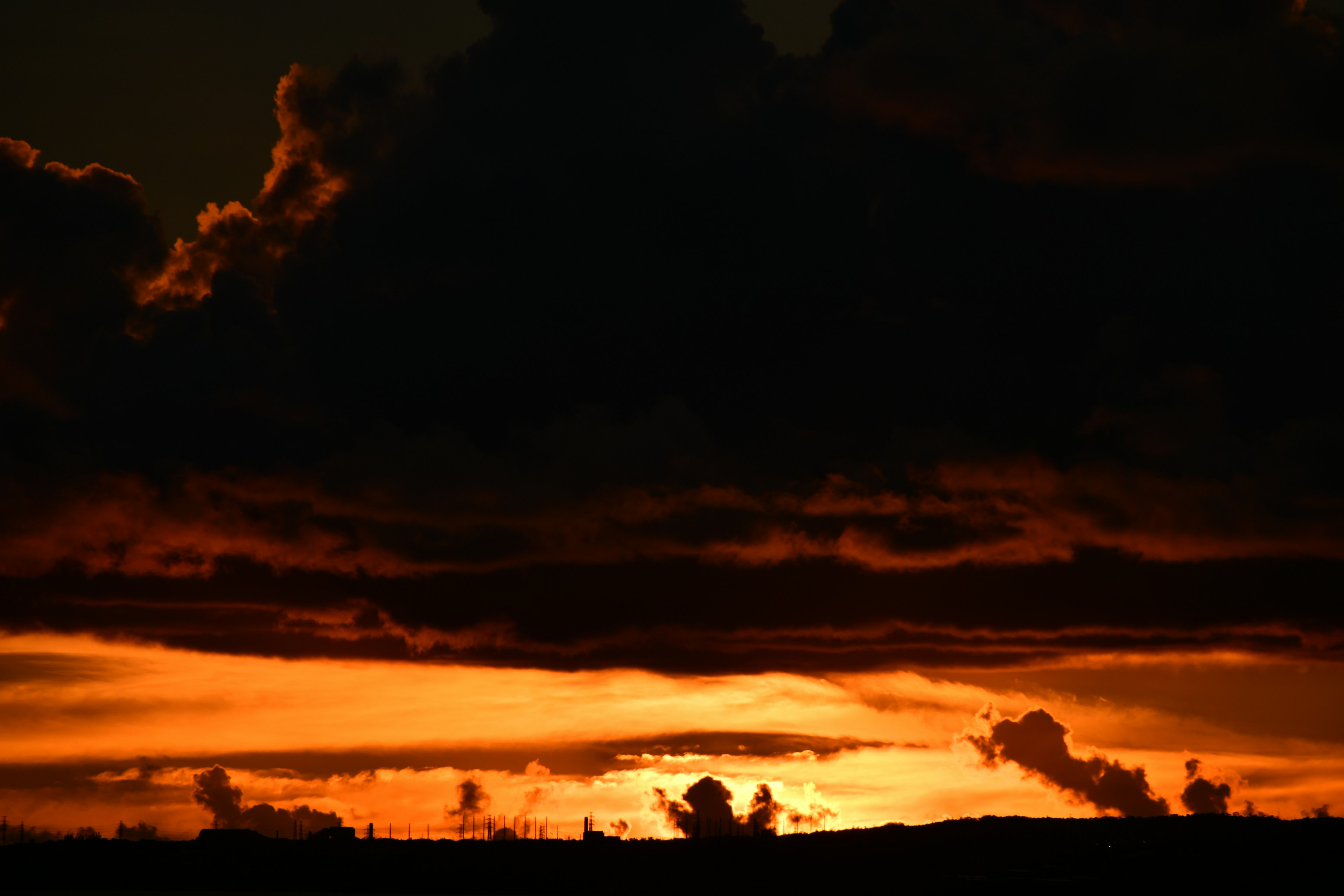 Bellissimo paesaggio al tramonto circondato da nuvole scure con luce arancione