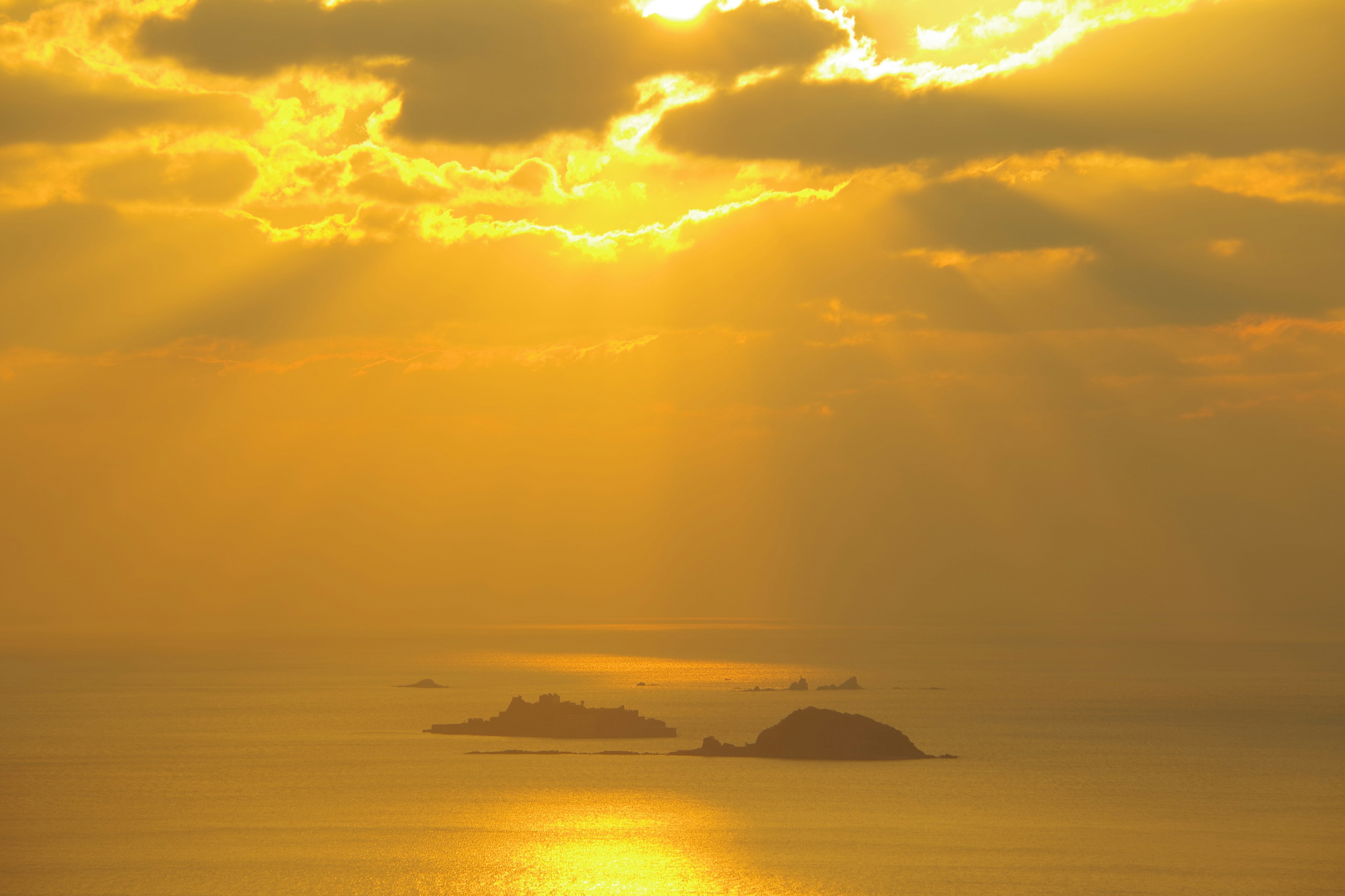 Un coucher de soleil illuminant la mer avec de petites îles