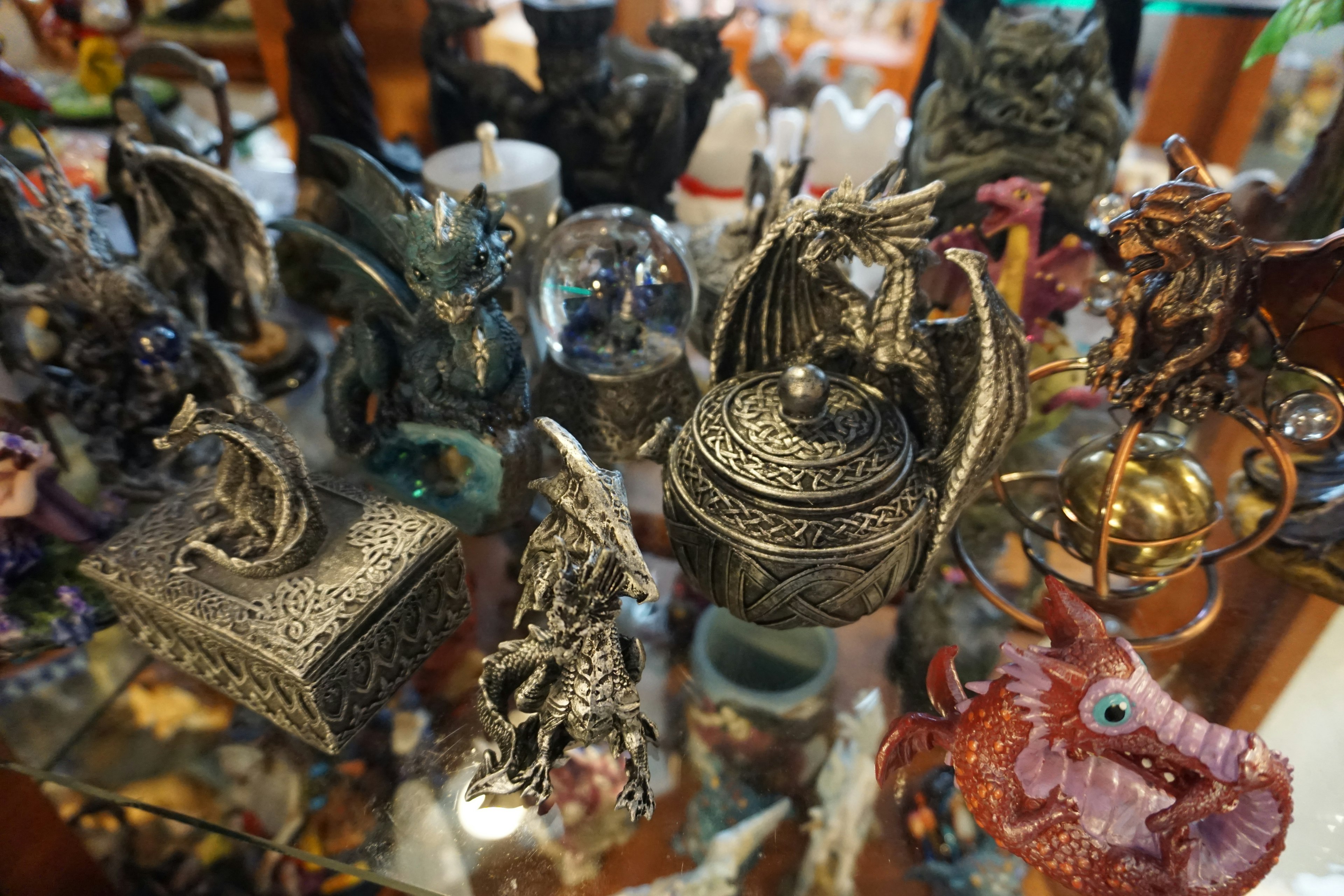 Una colección de esculturas de dragones y objetos decorativos exhibidos en una mesa