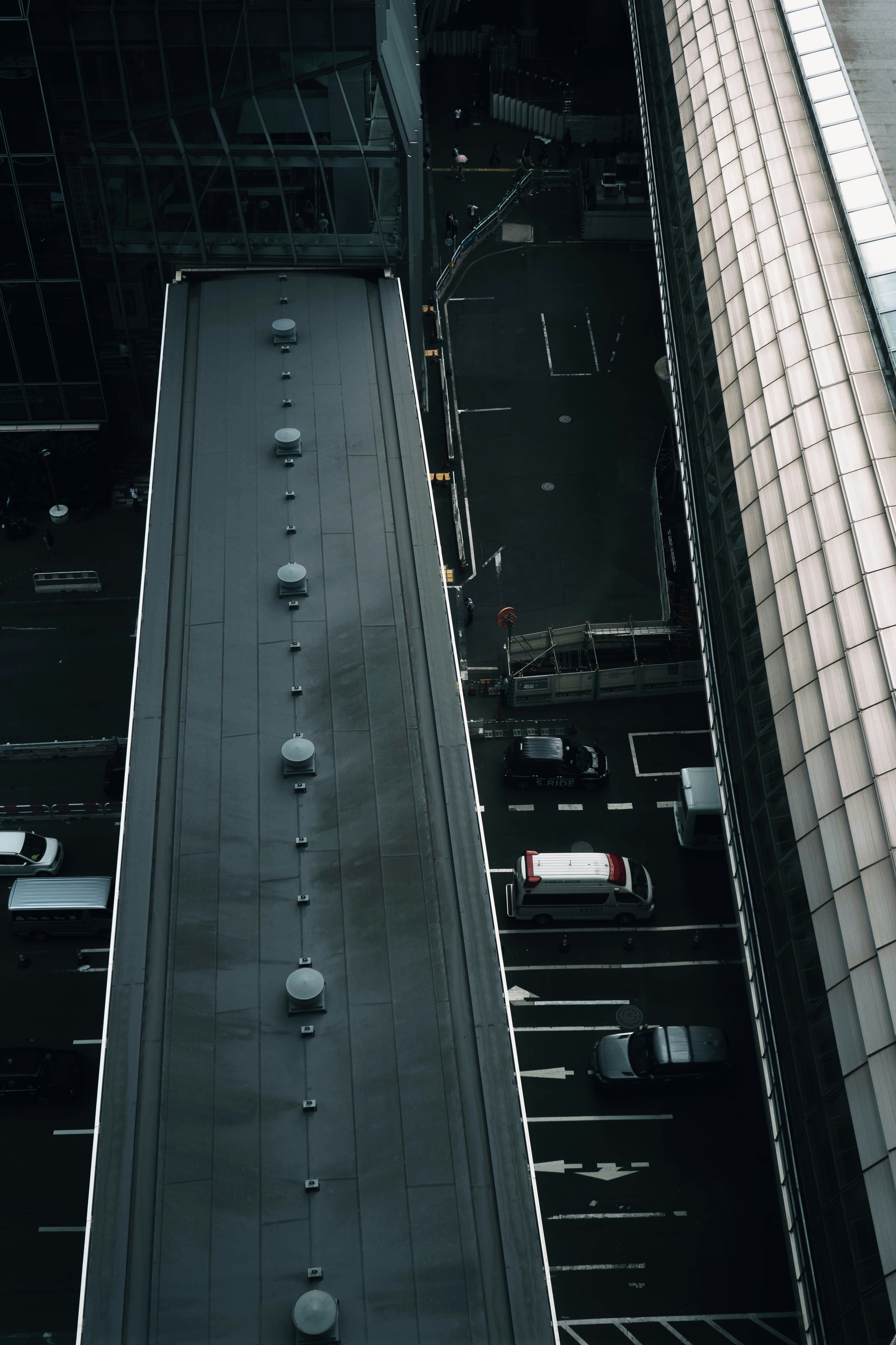 高層ビルの屋上から見た都市の風景 車道と建物が見える