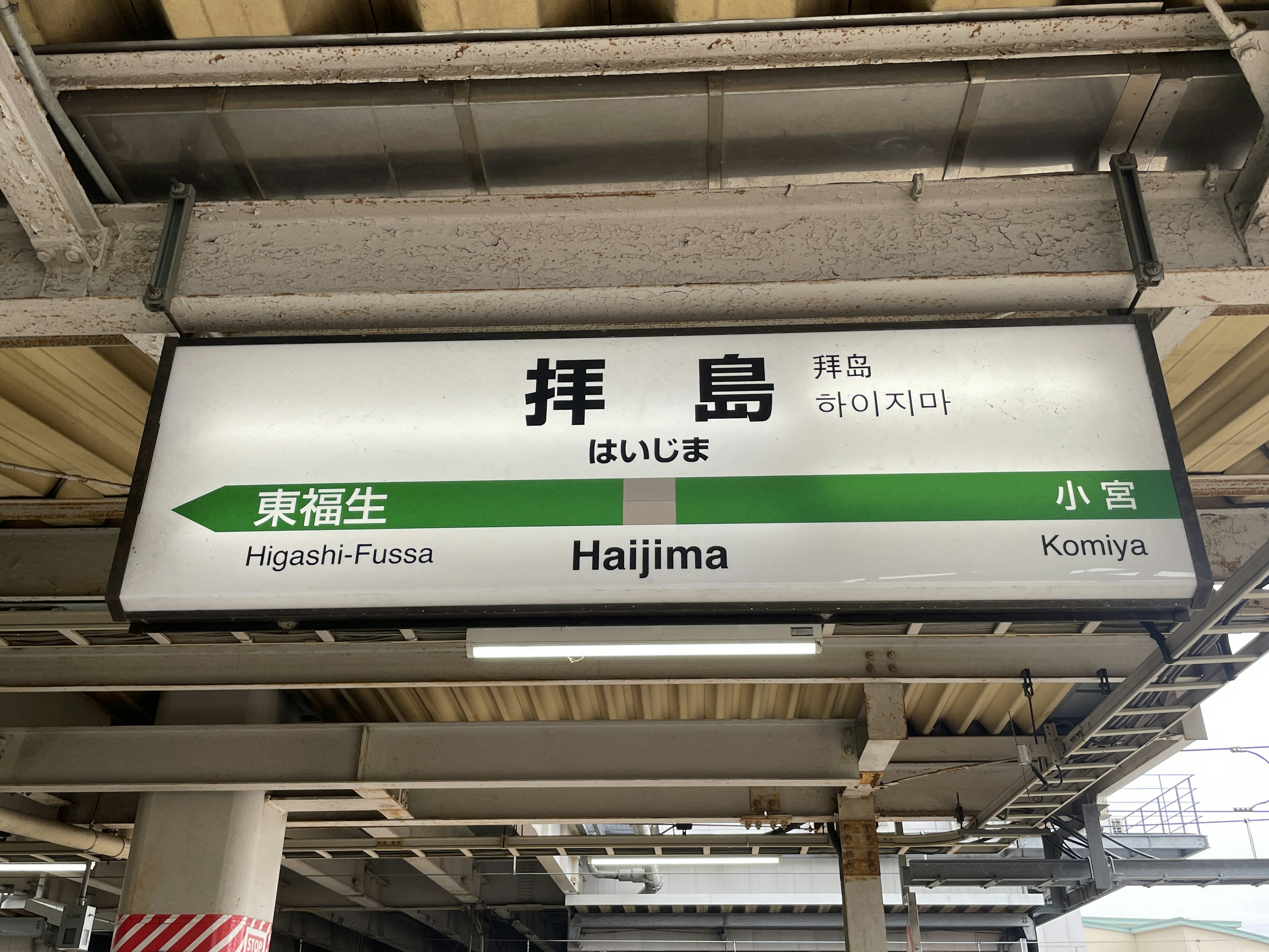 Tanda stasiun Haijima yang menampilkan nama stasiun dalam bahasa Jepang dan Inggris