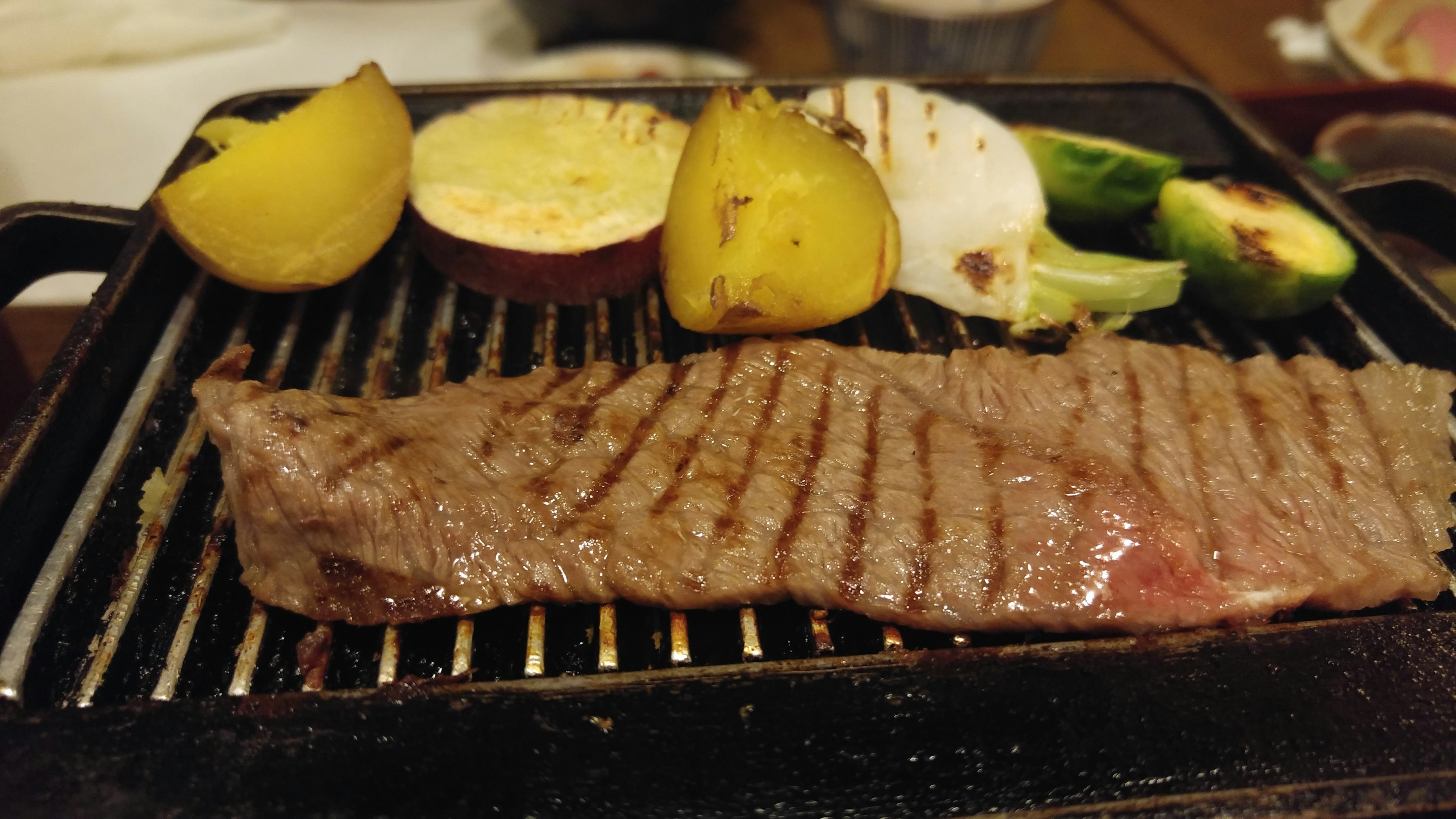 Bistec a la parrilla con verduras surtidas en un plato caliente