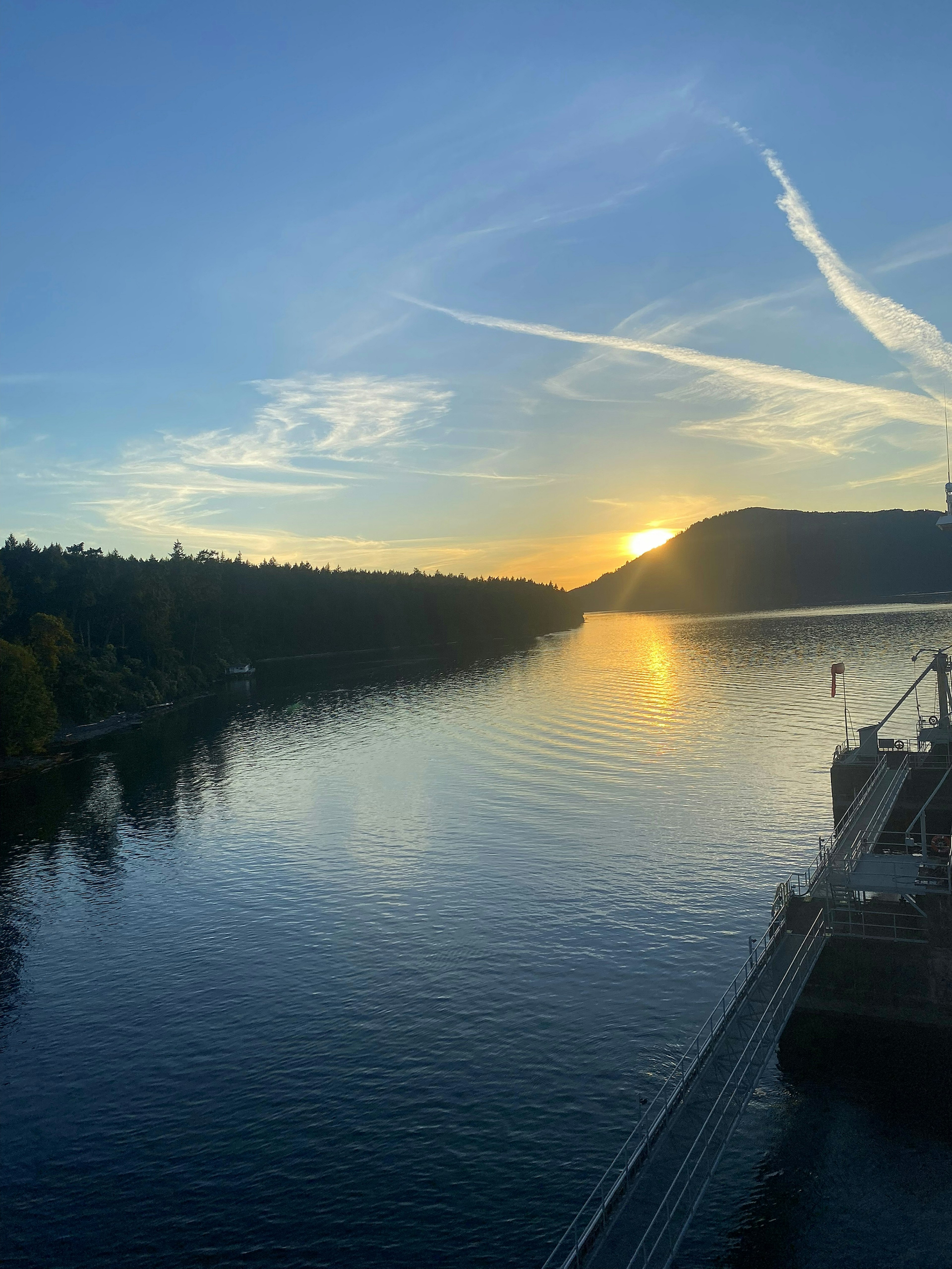 Vue panoramique d'une rivière au coucher du soleil avec des reflets sur l'eau et des rives verdoyantes