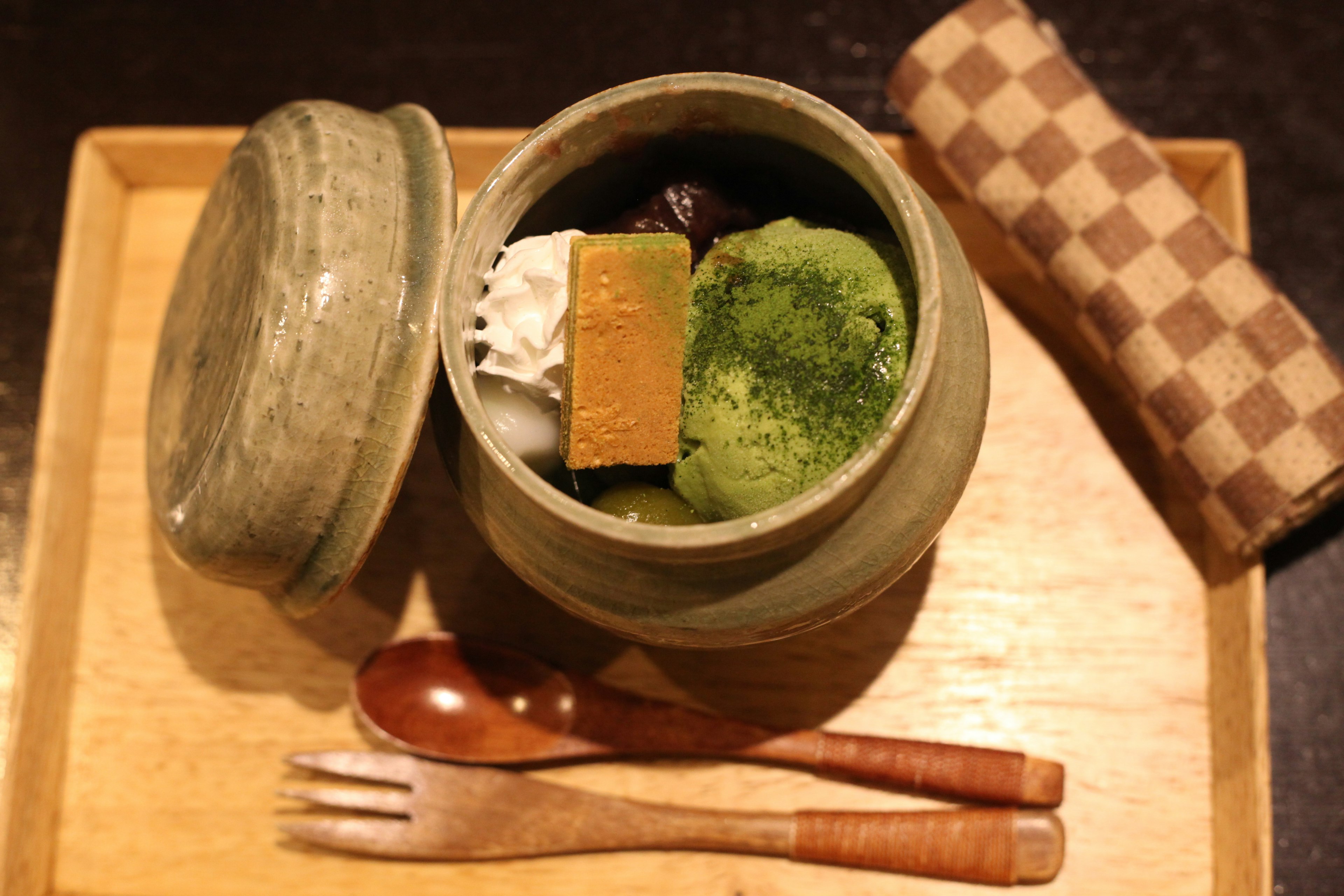 Contenedor de cerámica lleno de helado de matcha y dulces japoneses