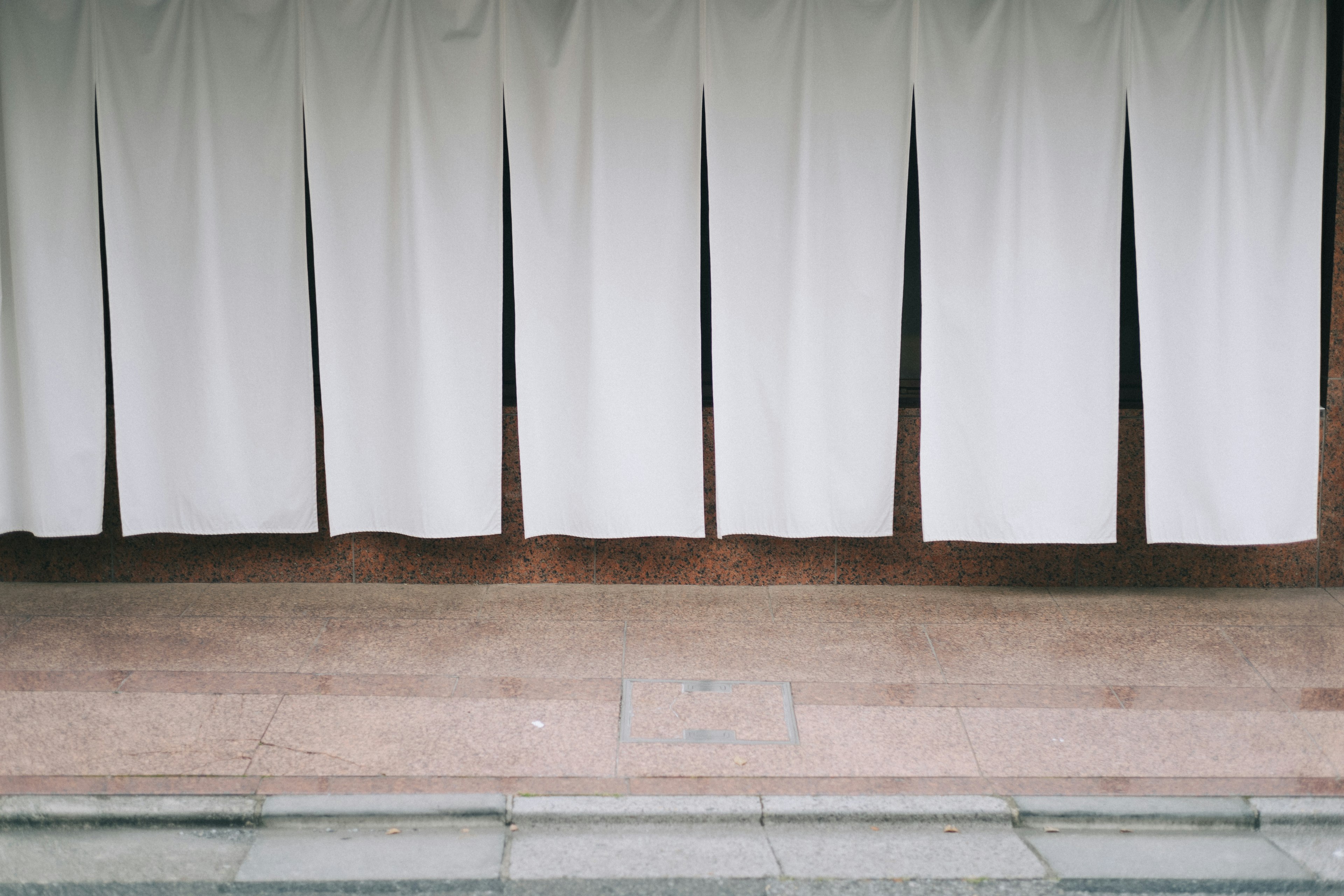 Entrance view of a store with hanging white curtains