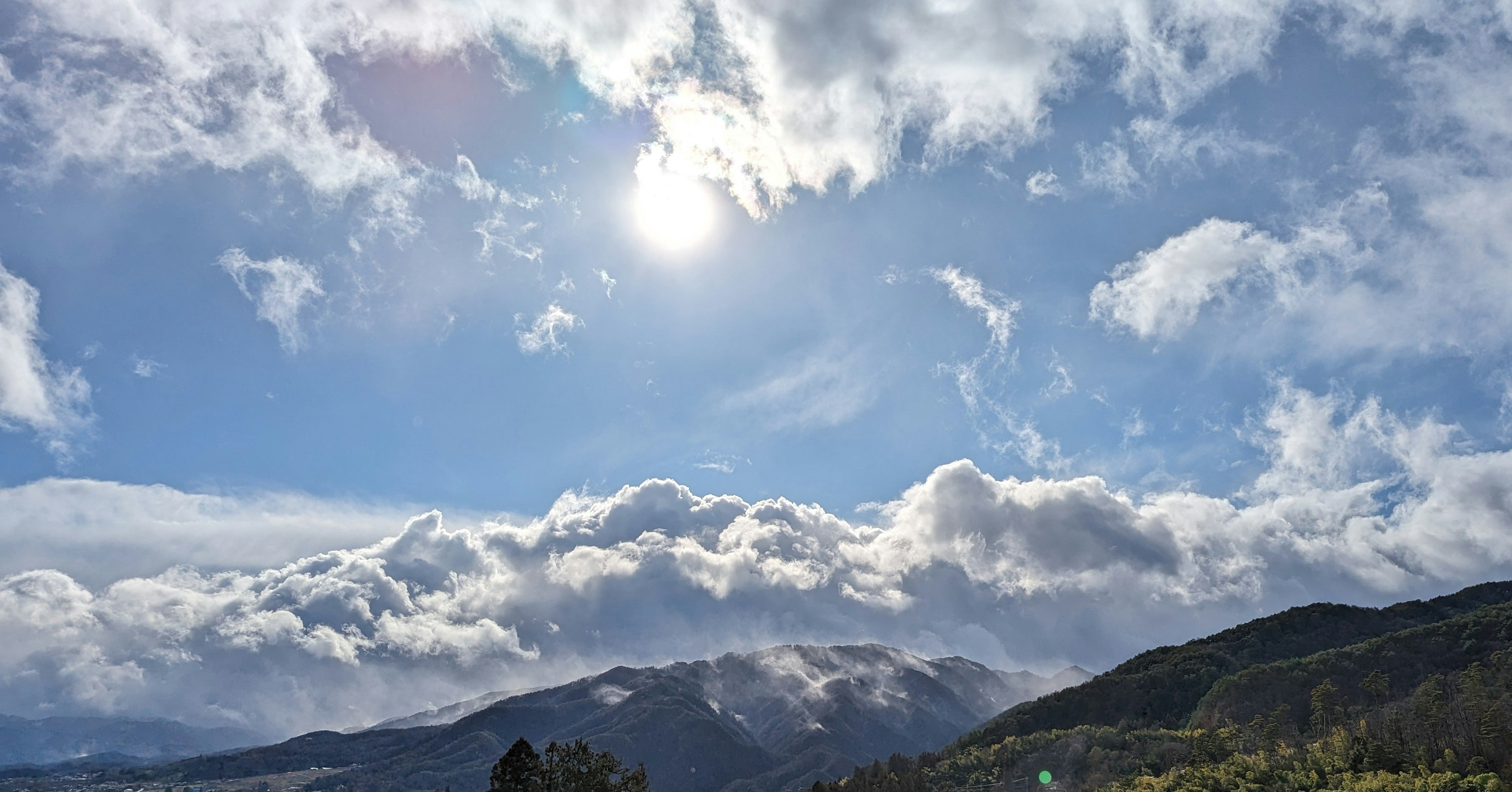 Hermoso paisaje con nubes y sol en un cielo azul