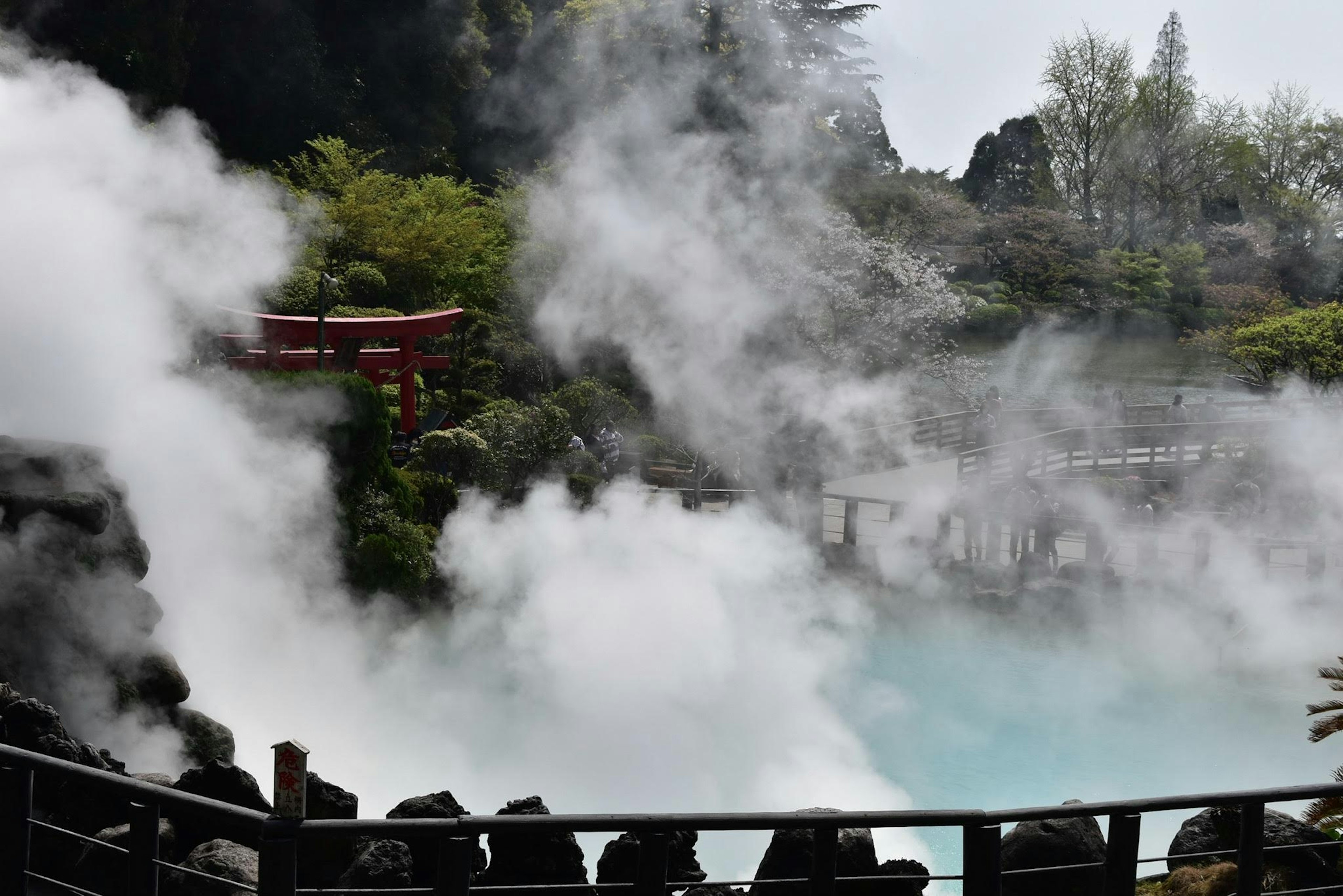 Cảnh quan thiên nhiên với suối nước nóng bốc hơi cổng torii đỏ có thể thấy