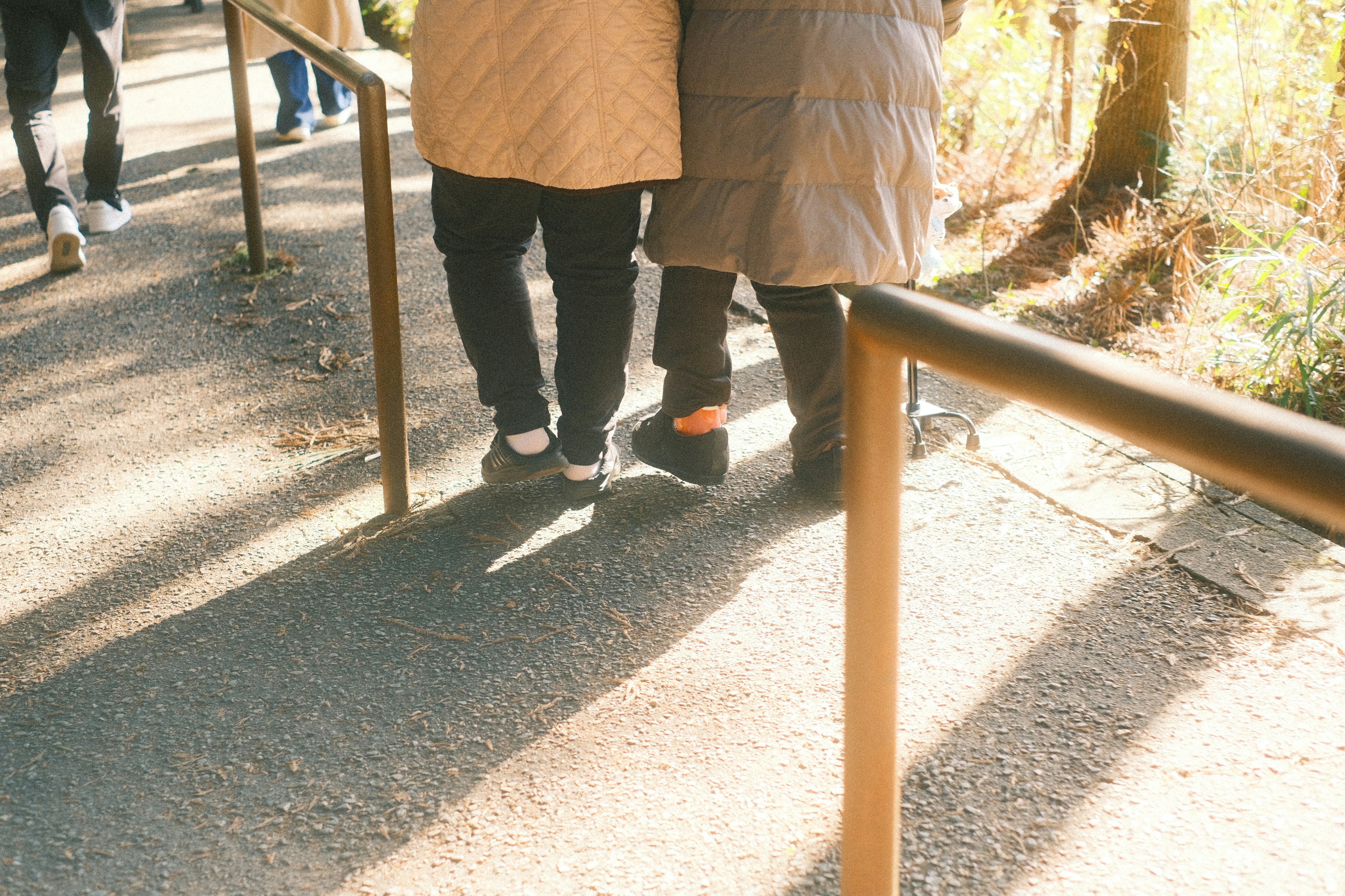 人々が歩道を歩いている様子と手すり