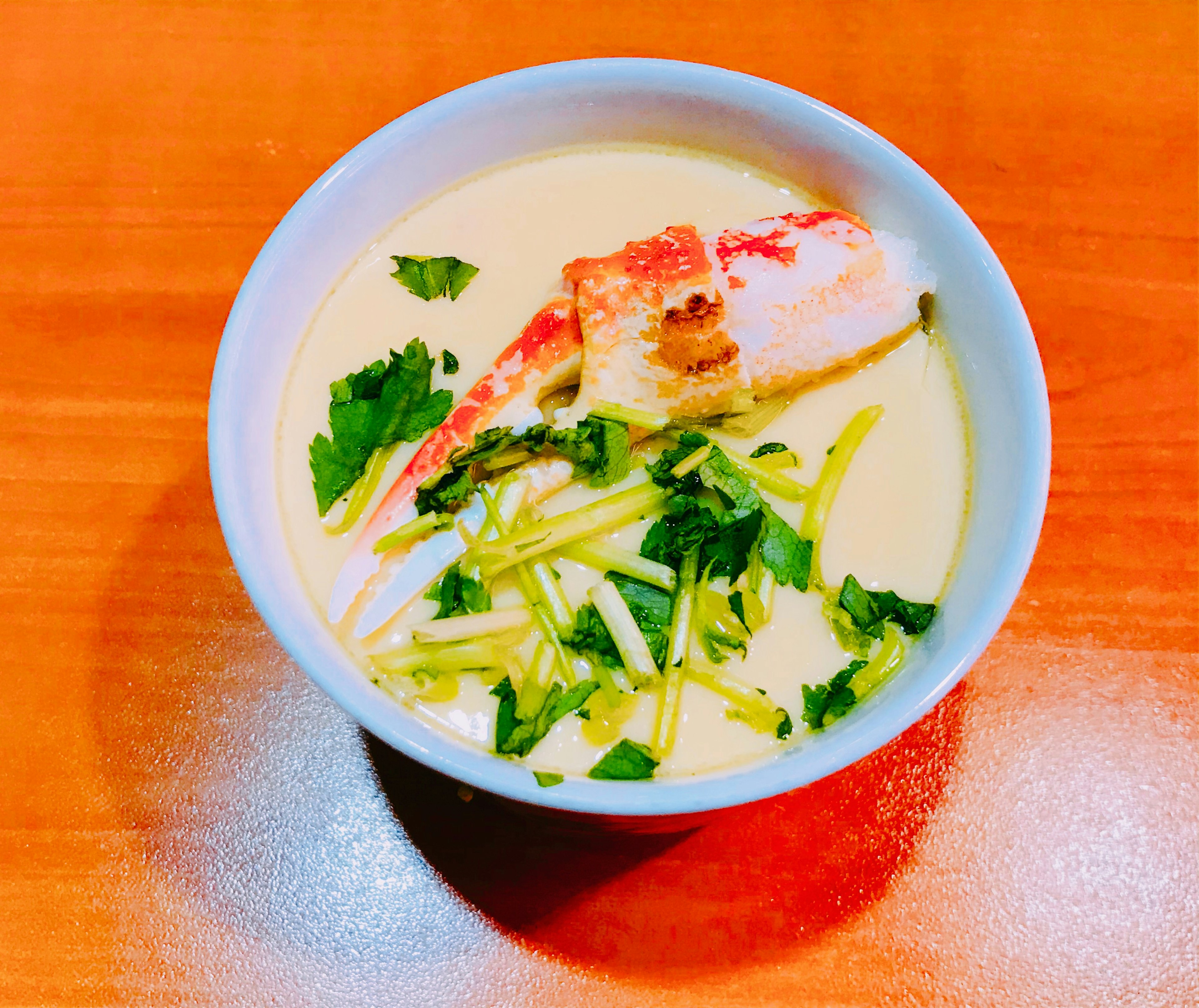 Creamy soup with large shrimp and green onions