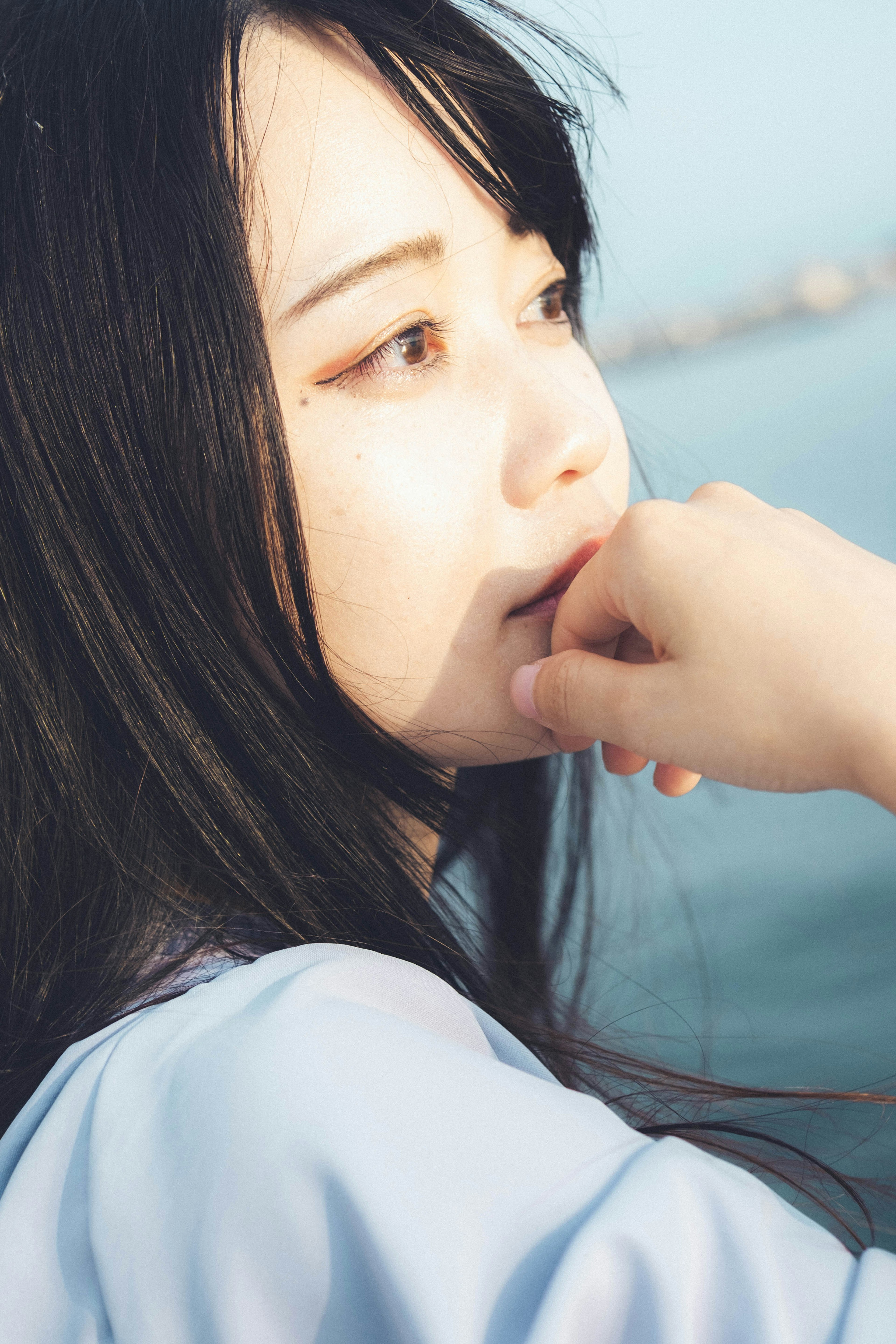 Profile portrait of a woman with the sea in the background