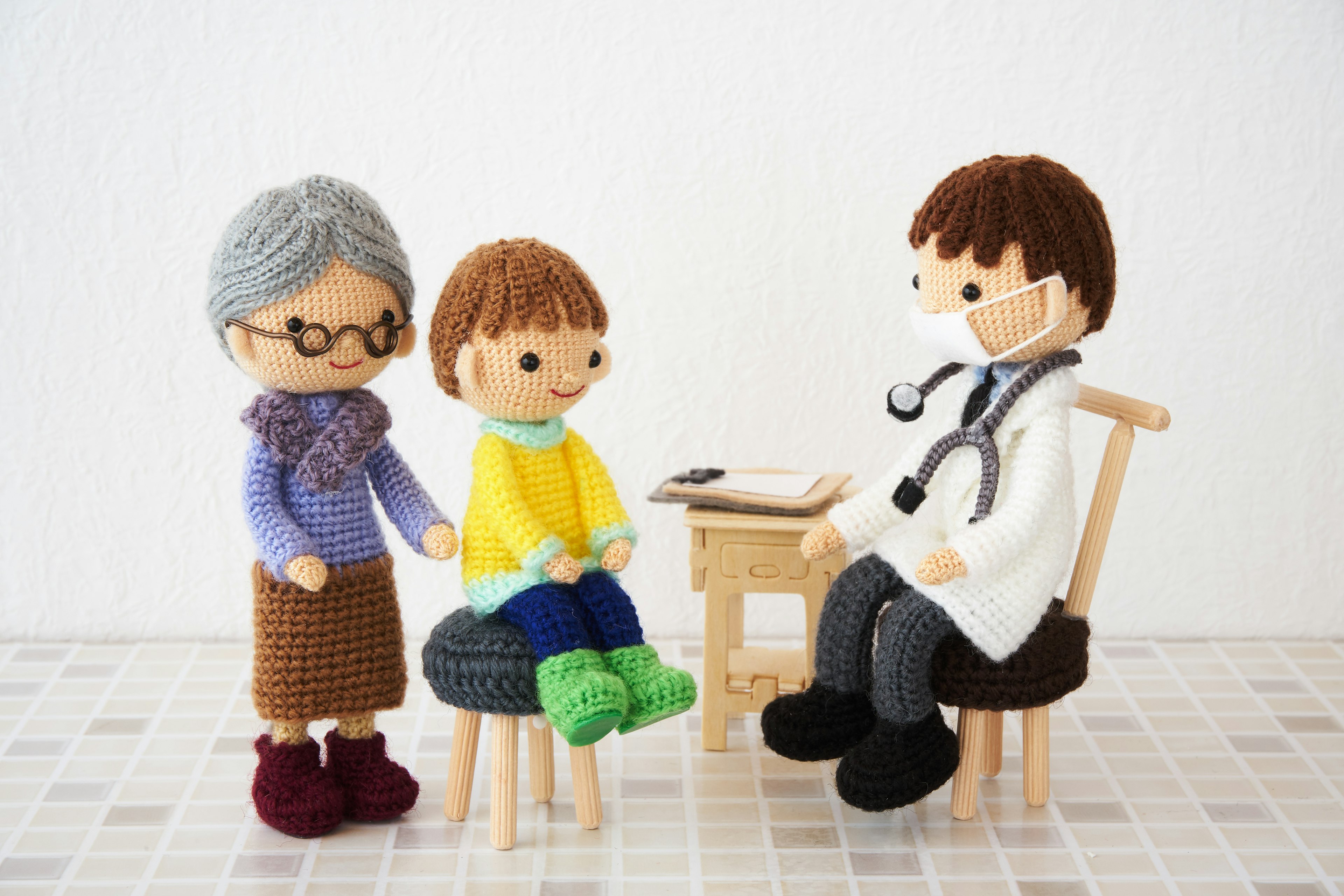 Poupées au crochet d'un médecin et d'un patient dans une scène de consultation