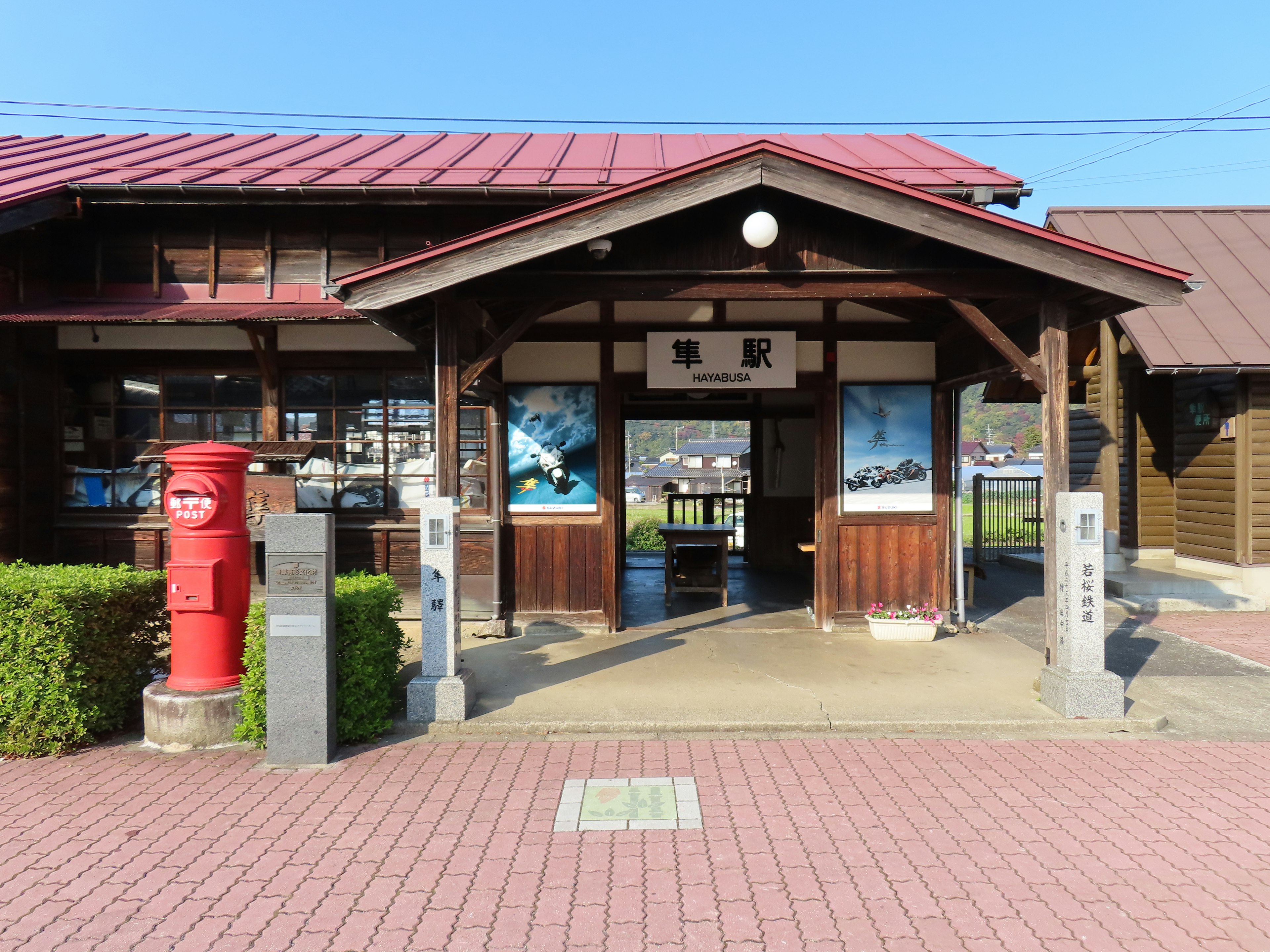 Wooden train station with a red roof prominent mailbox