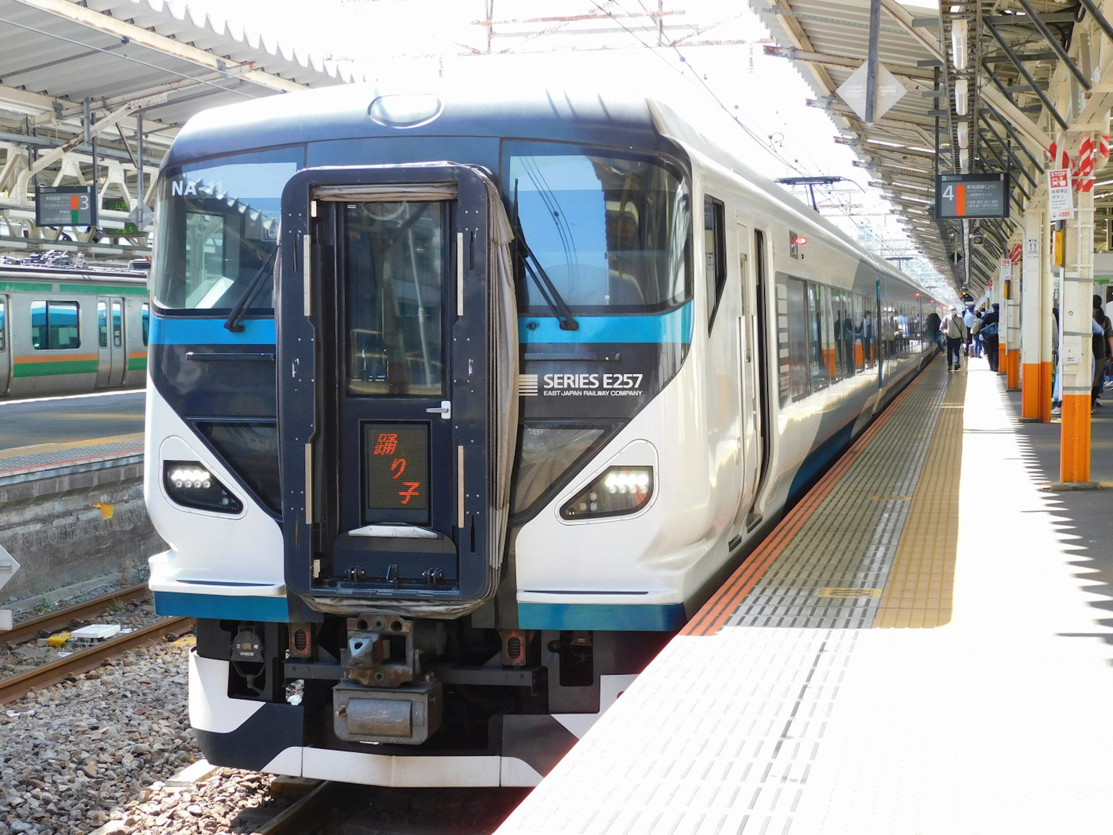 A blue and white train is stopped at a station