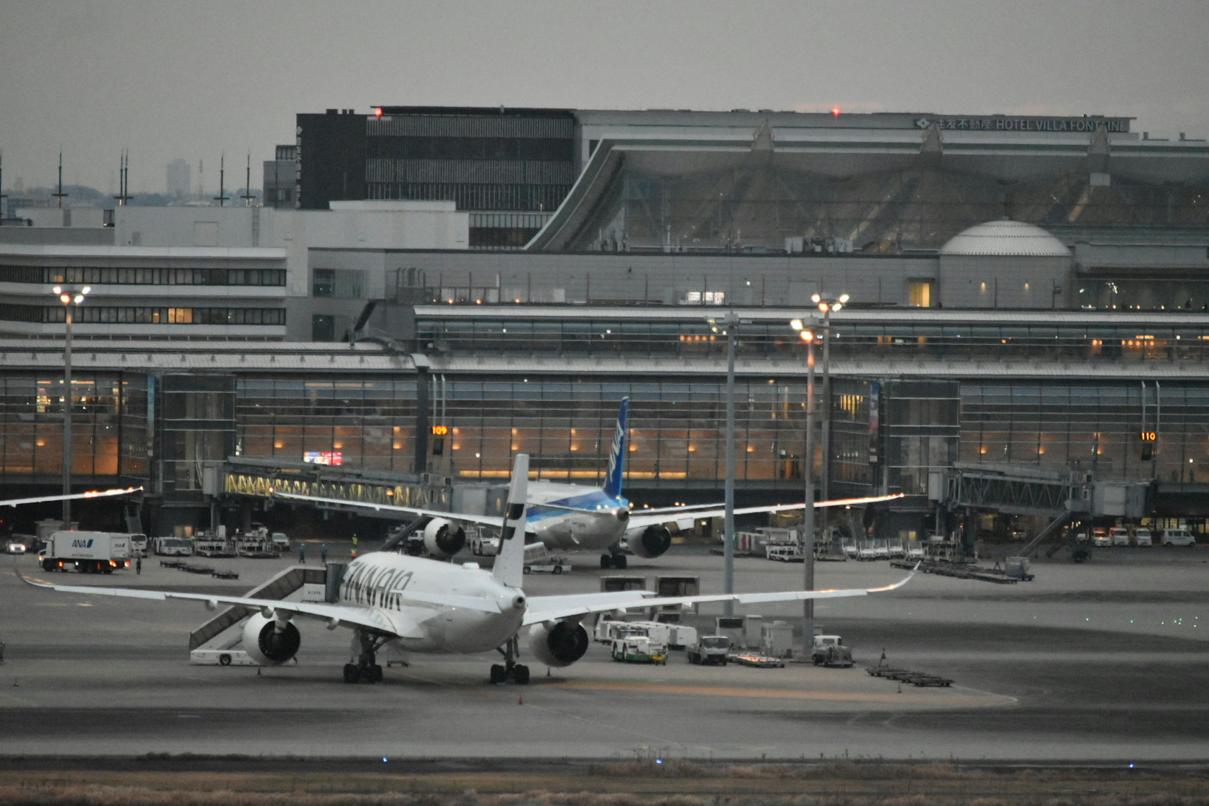 황혼에 비행기가 있는 공항 터미널의 모습