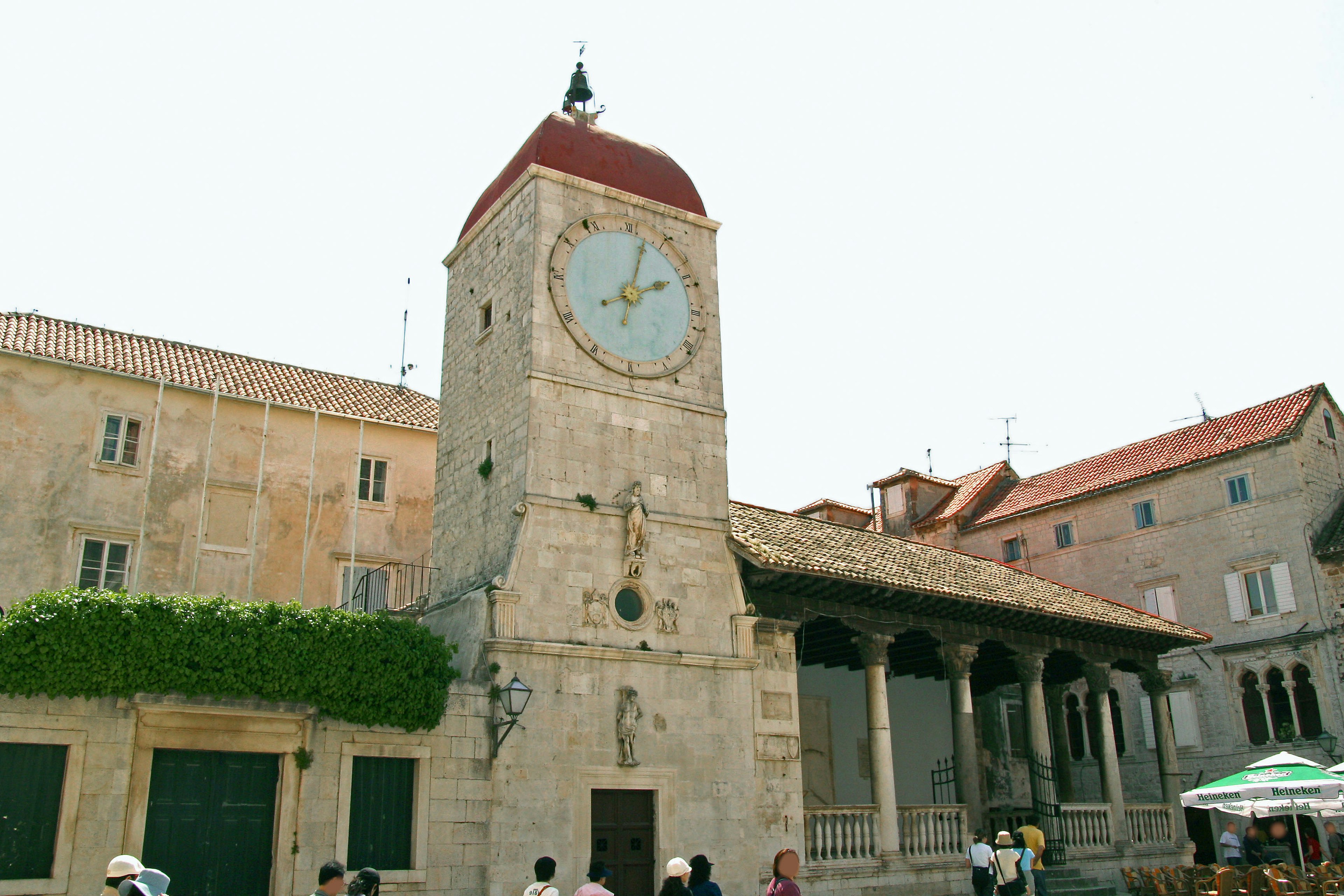 Plaza histórica con torre del reloj y edificios de piedra