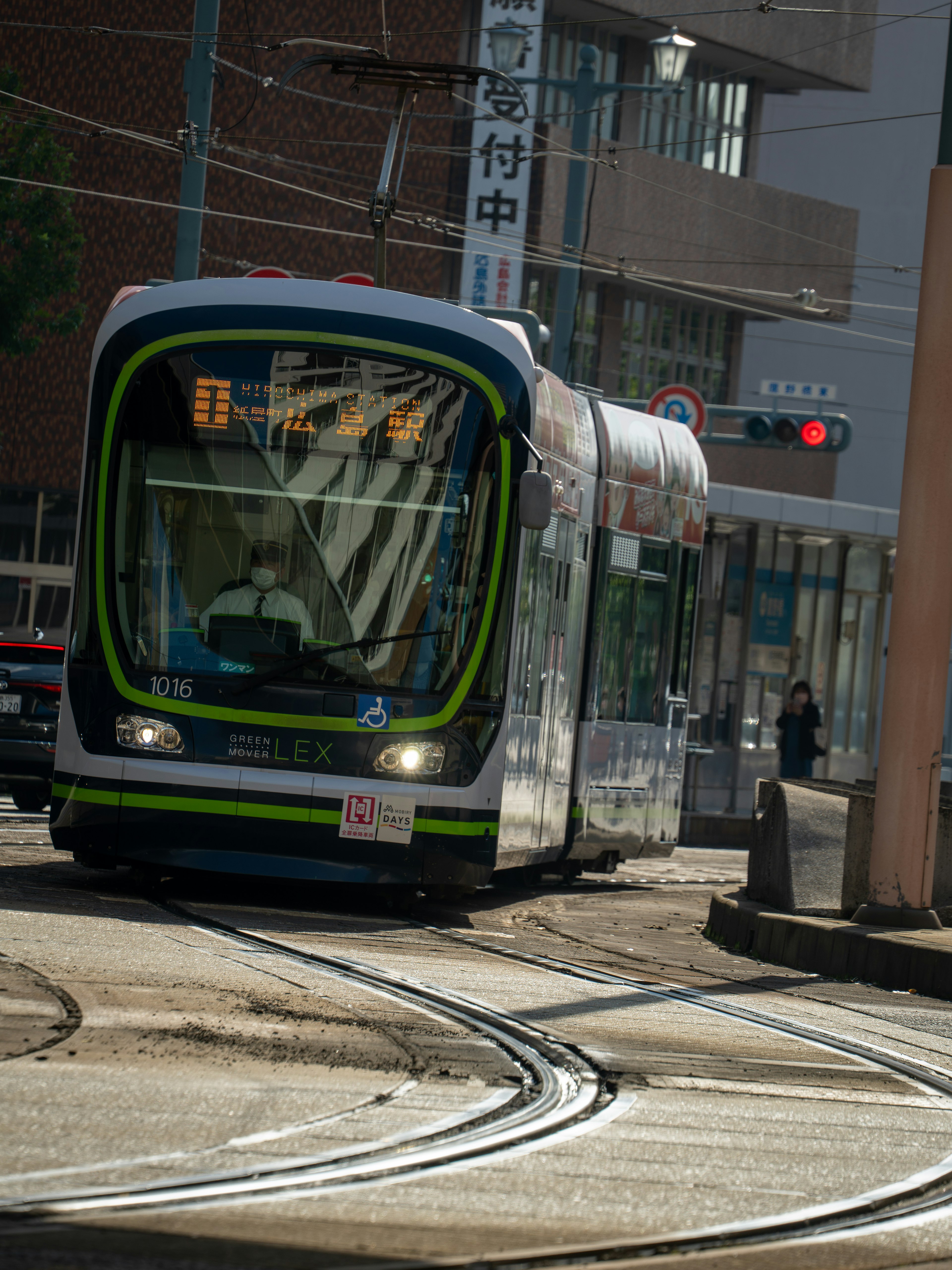 Tram girando en una calle con semáforo y edificios visibles