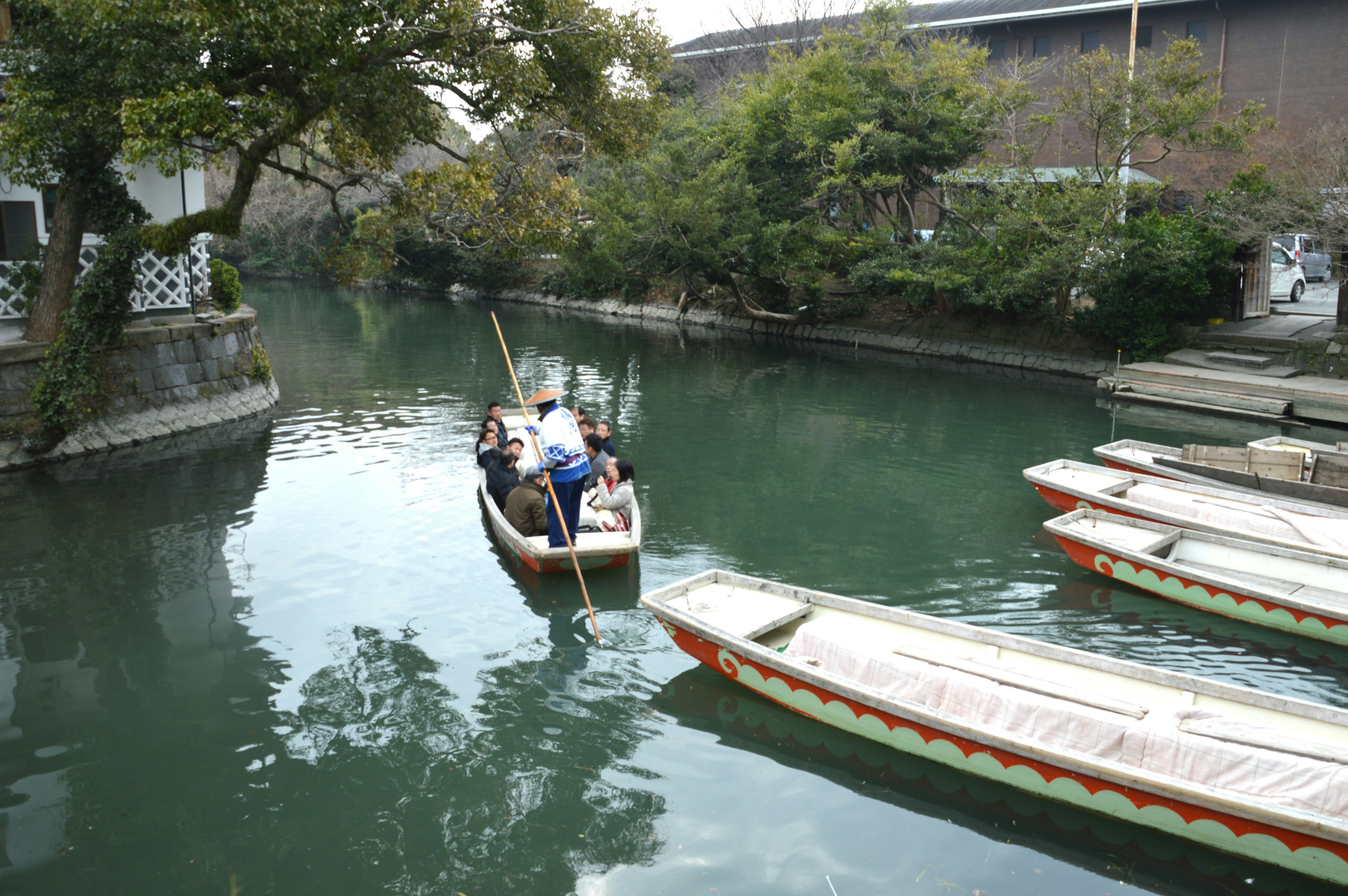 A small boat on a serene canal surrounded by lush greenery