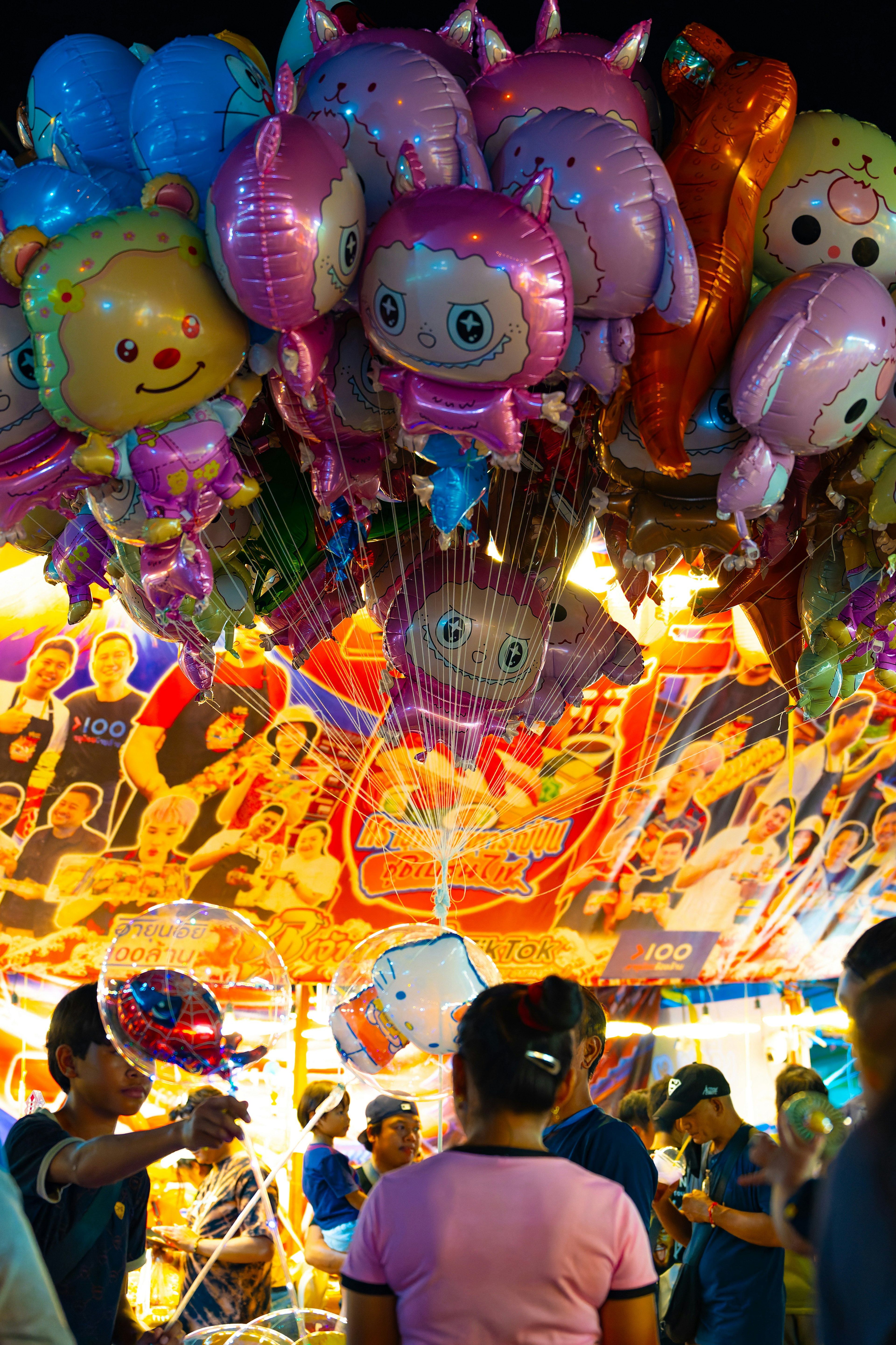 Une scène festive avec des ballons de personnages colorés suspendus au-dessus dans une ambiance animée