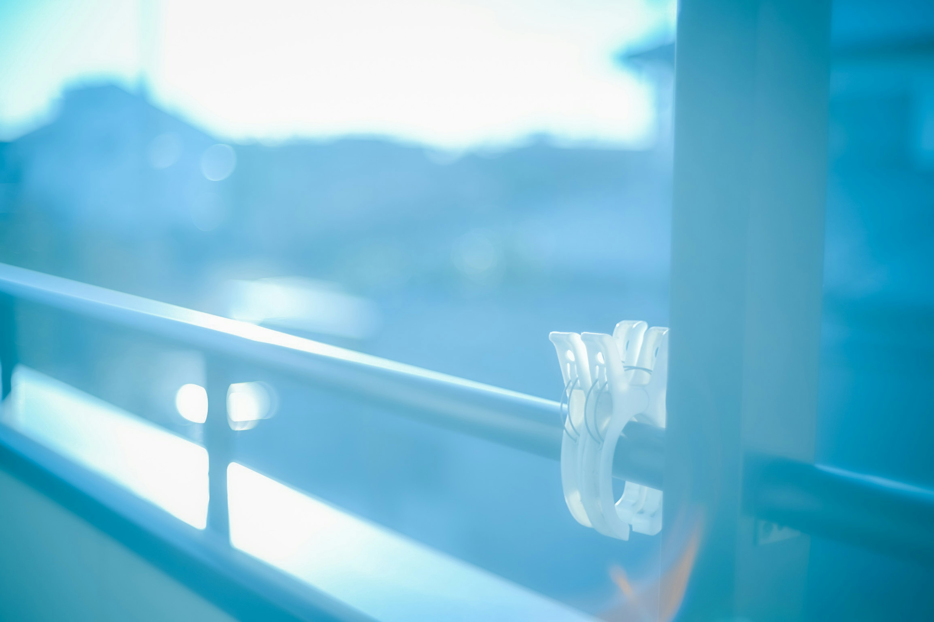 Transparente Klammer an einem Fensterhandlauf in sanftem blauem Licht