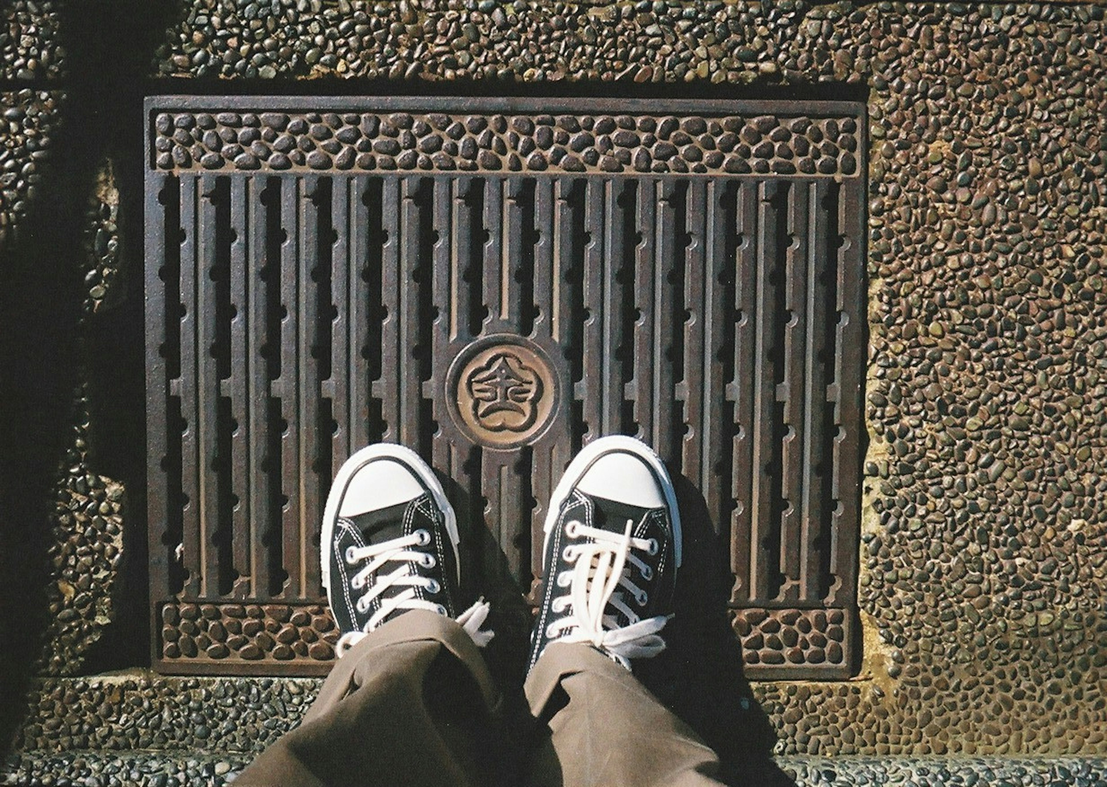 Couvercle de regard en métal avec des baskets posées dessus