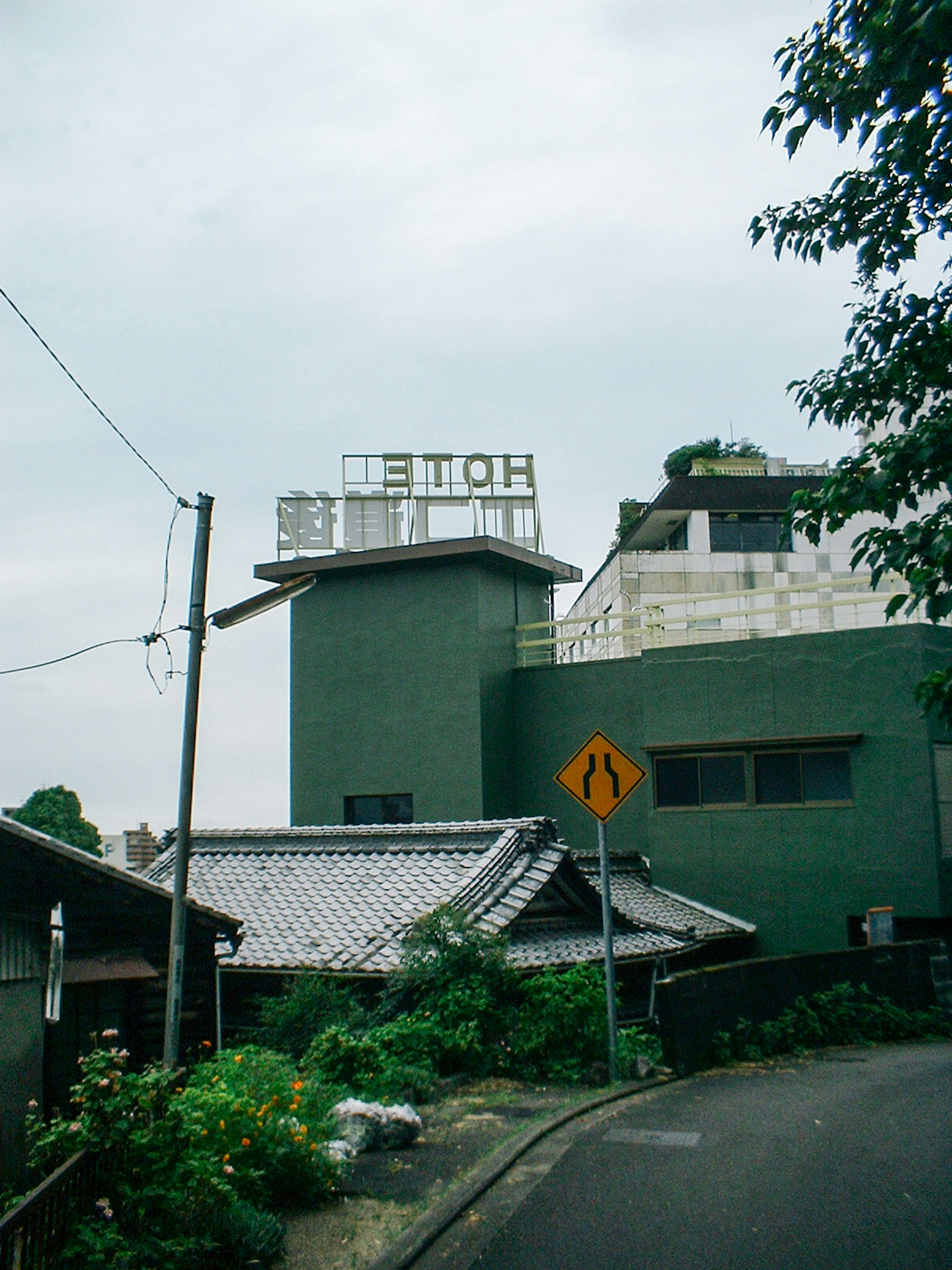 A green building with a sign that reads 'HOTEL' on top