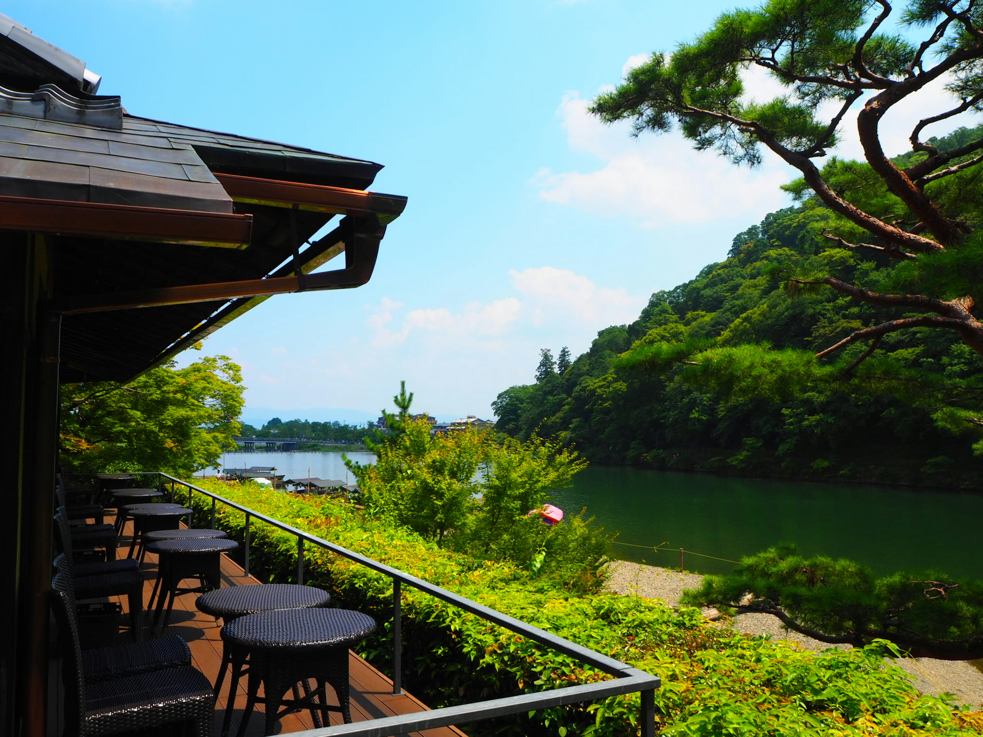 美しい川沿いの風景と緑豊かな山々を背景にしたカフェのテラス