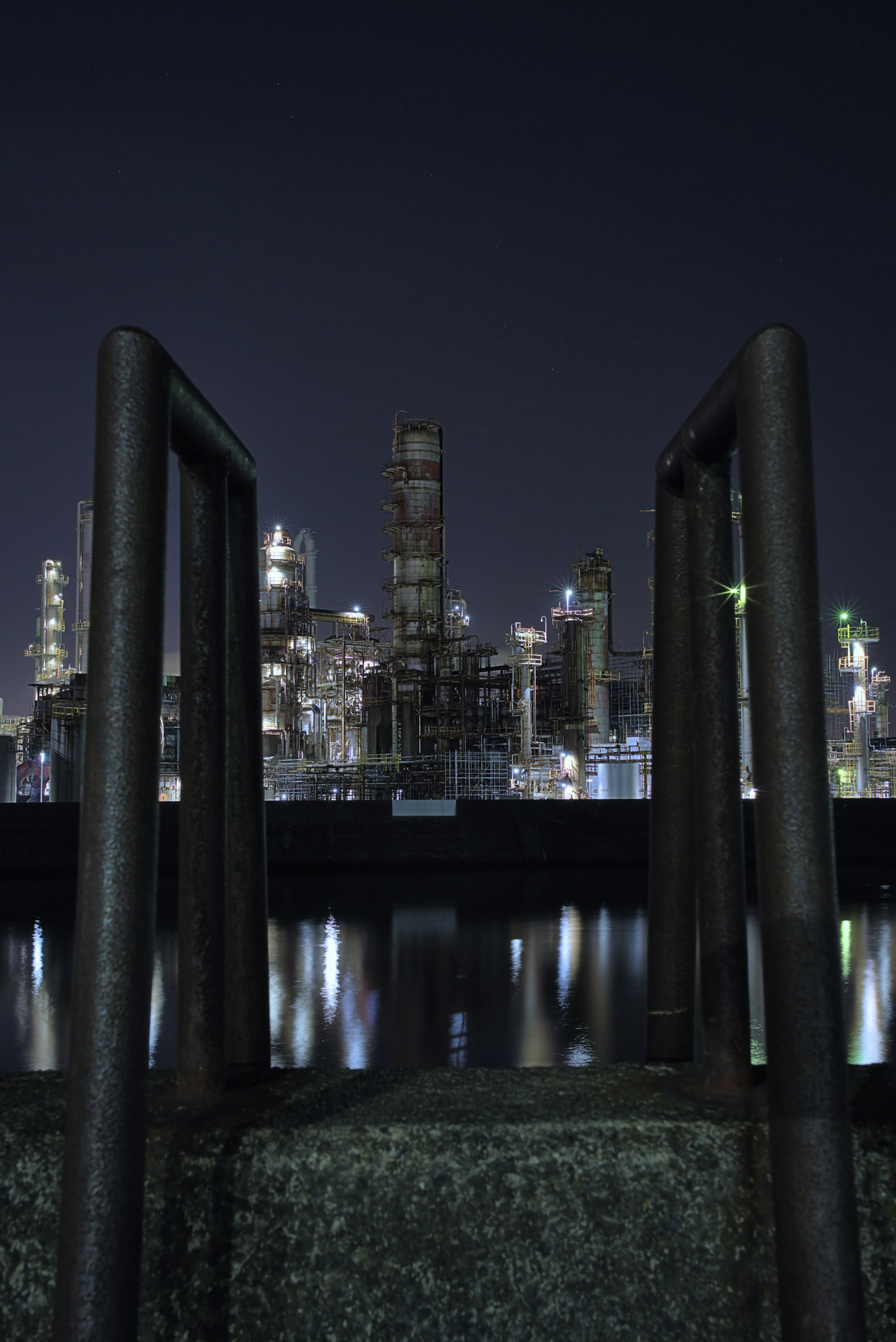 Rampes métalliques encadrant une vue nocturne d'une zone industrielle