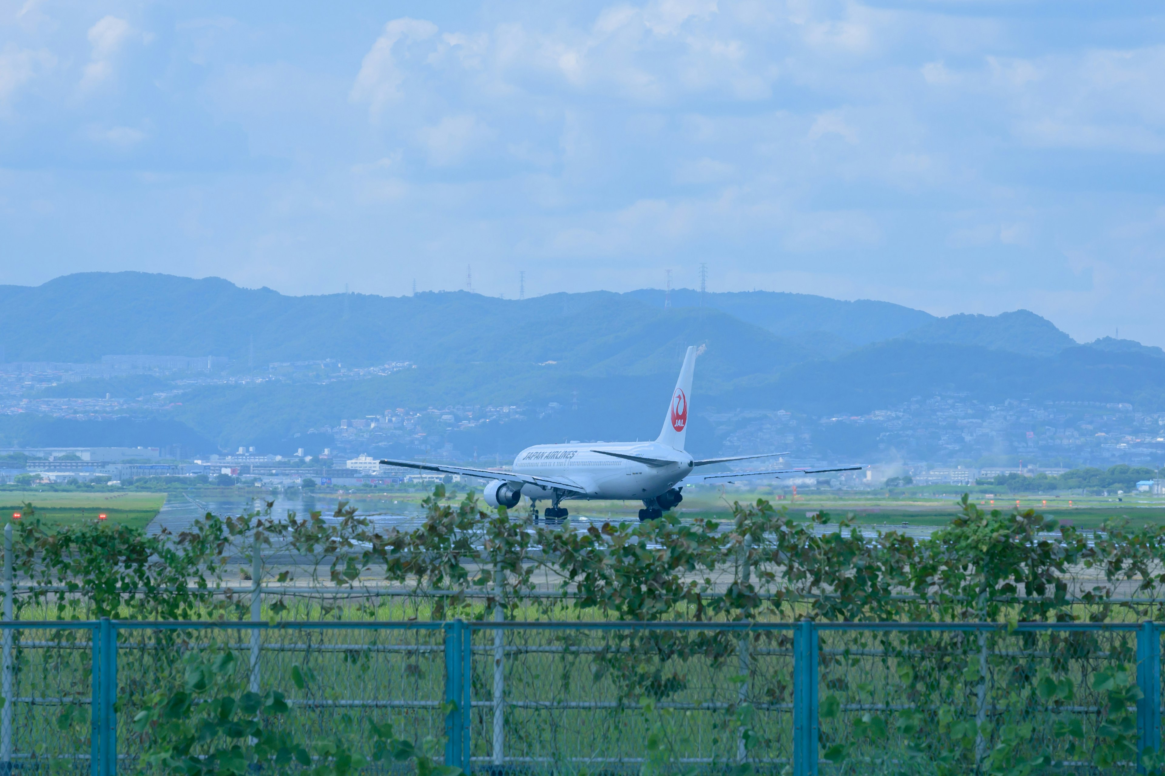 Flugzeug auf der Landebahn mit blauem Himmel und Bergen im Hintergrund