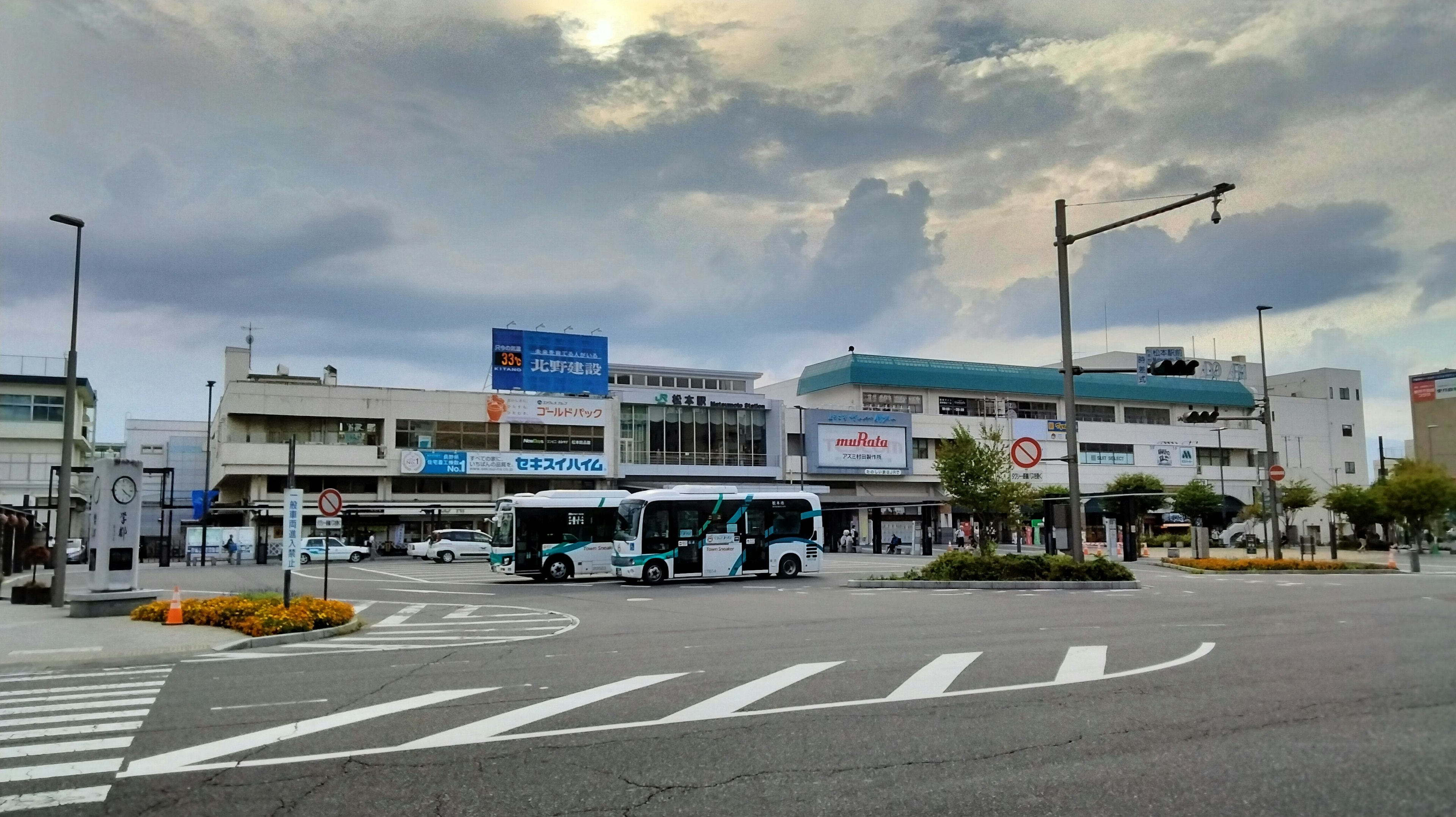 View of a bus stop and buildings in front of a station