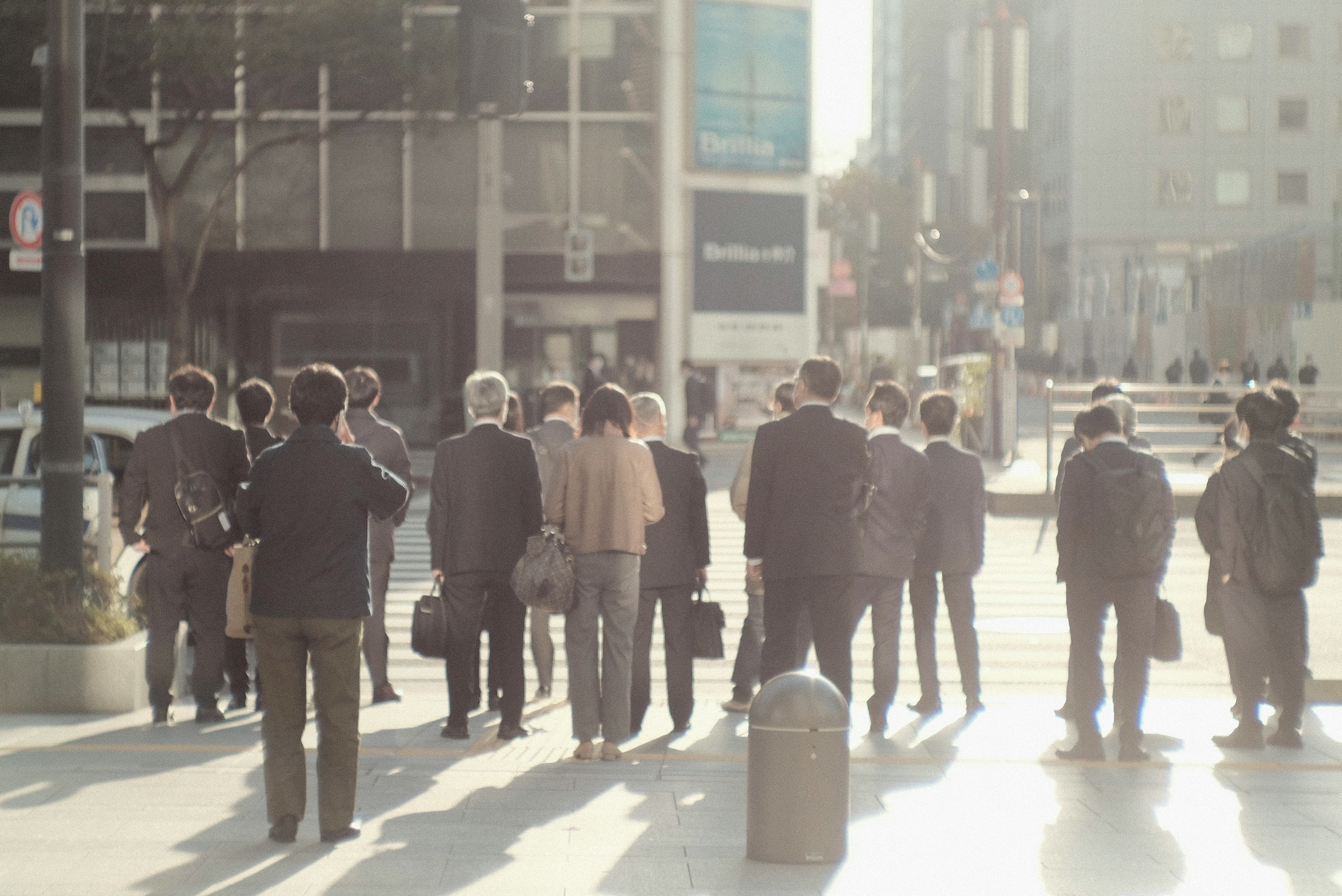 A group of businesspeople waiting at a crosswalk in a city