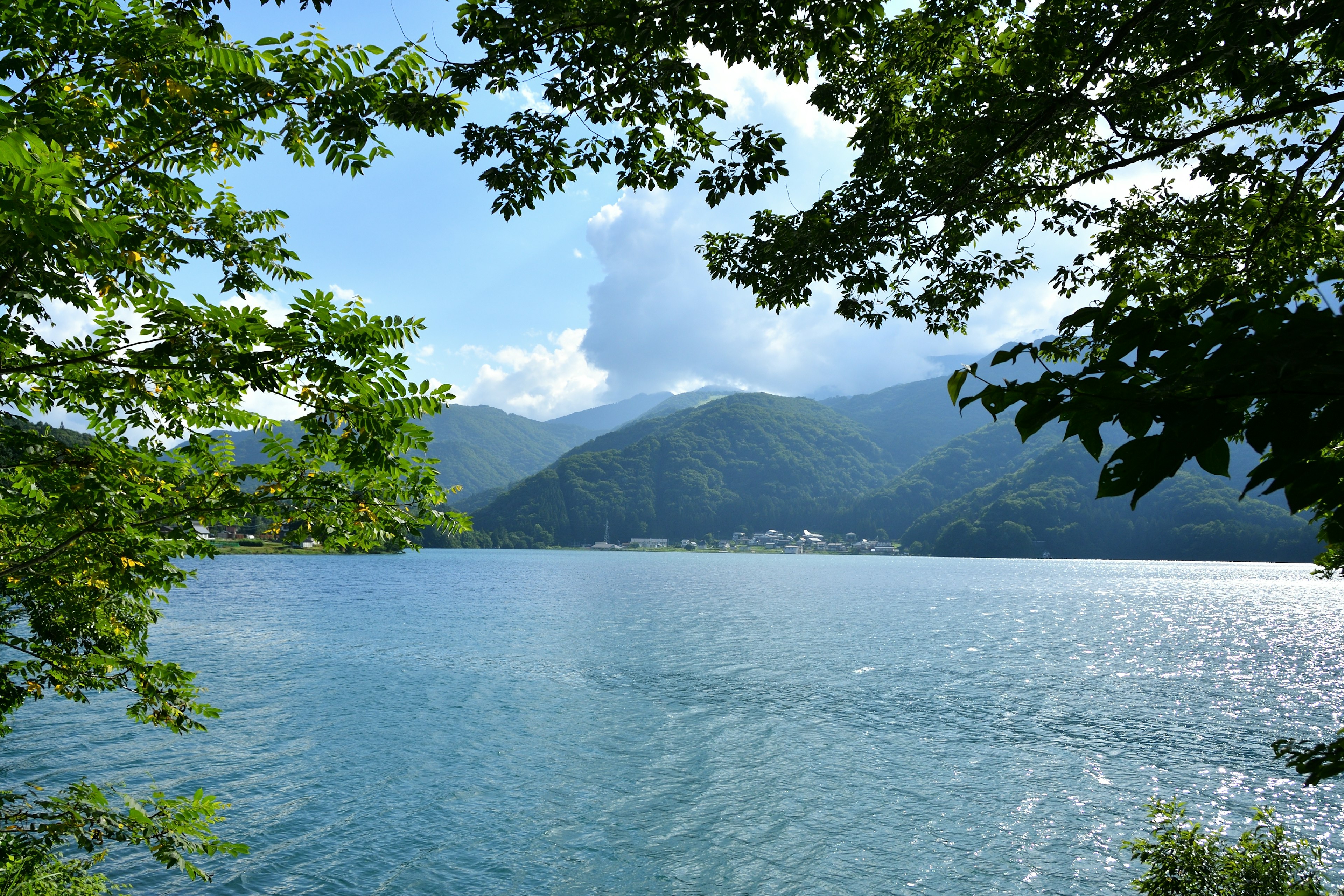 Malersicher Blick auf einen See, umgeben von Bergen und Grün