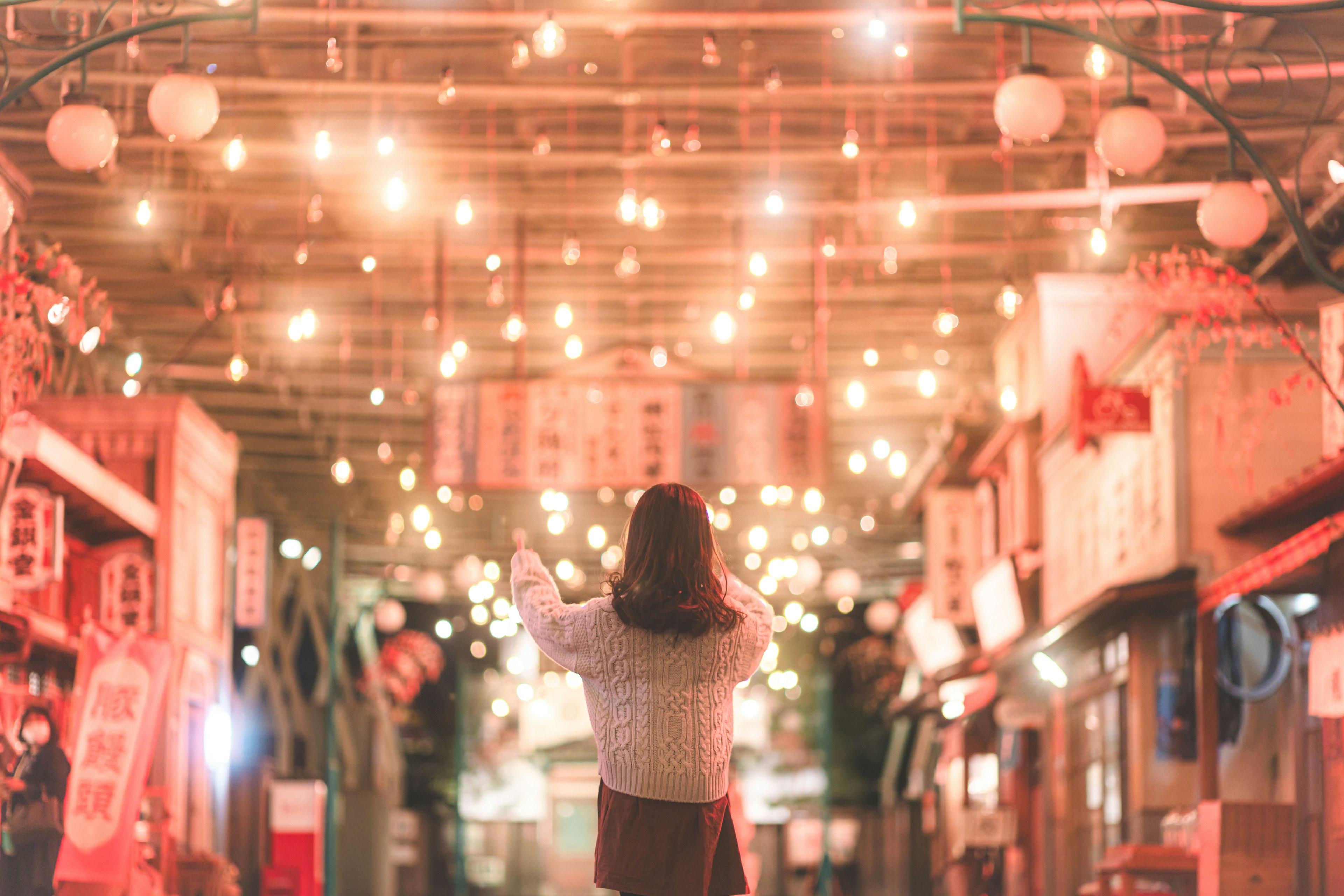 一位女性仰望着美丽照亮的户外市场