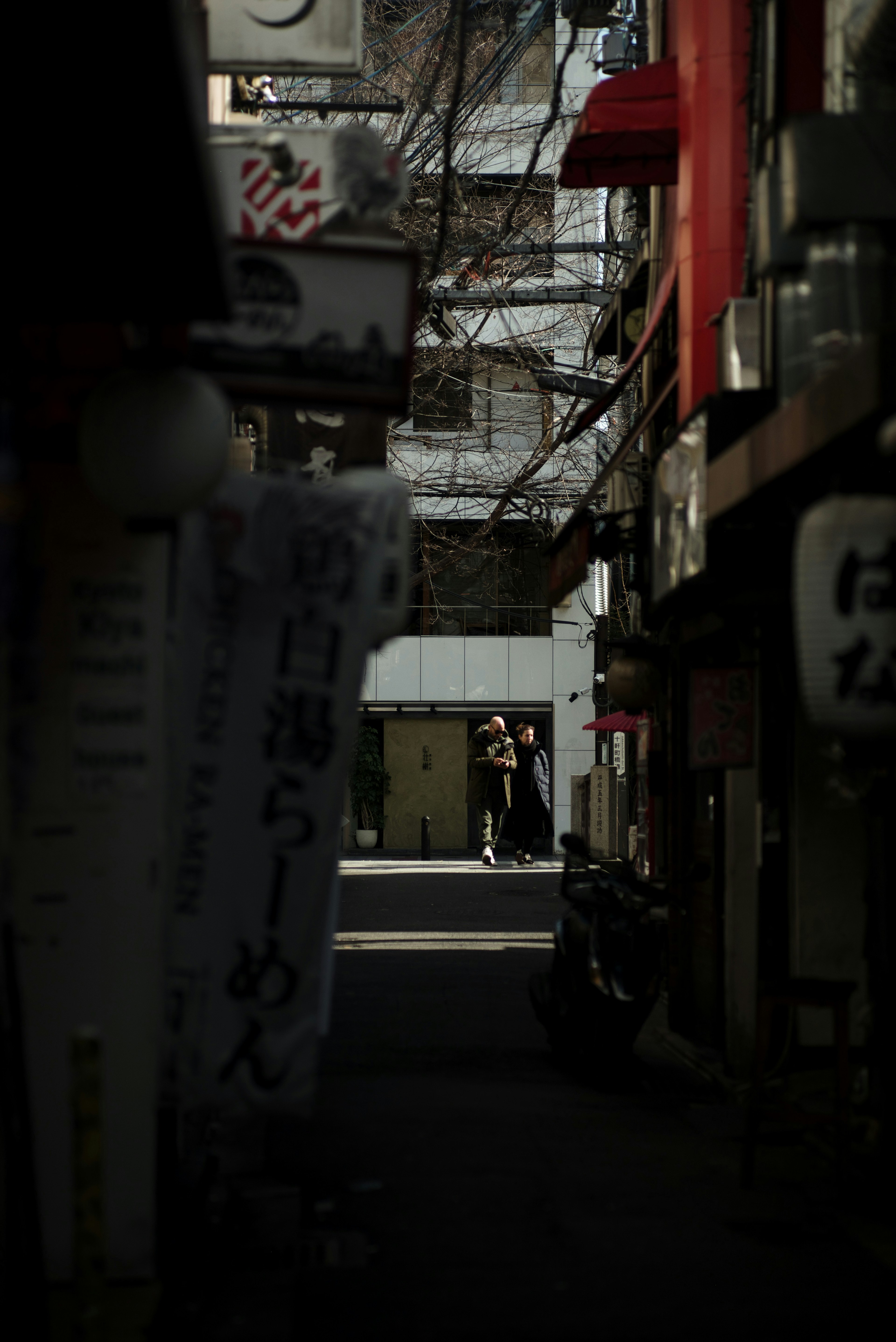 薄暗い路地に立つ人影と看板