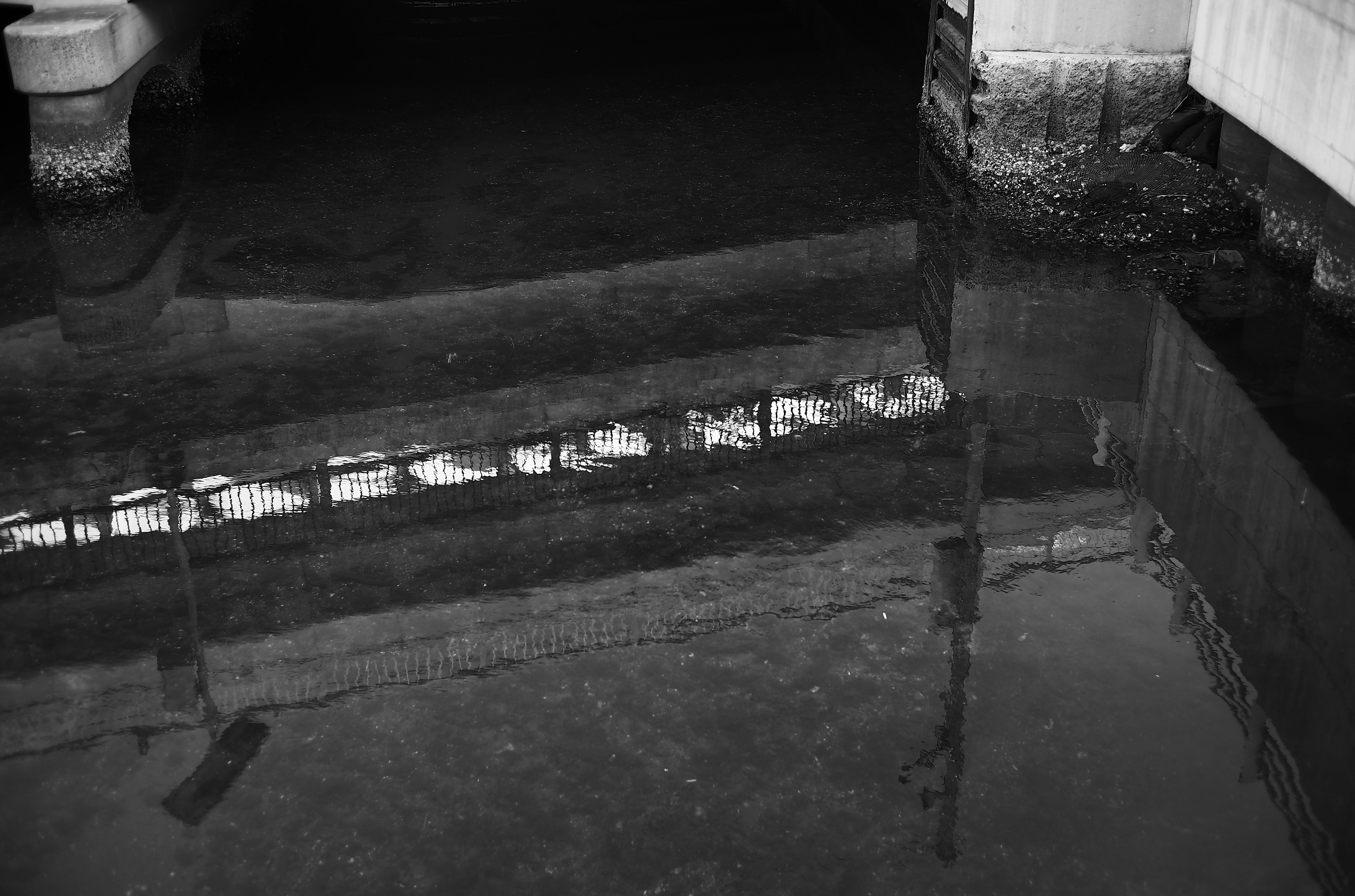 Reflection of a building on a black and white water surface Dark ambiance with a sense of calm