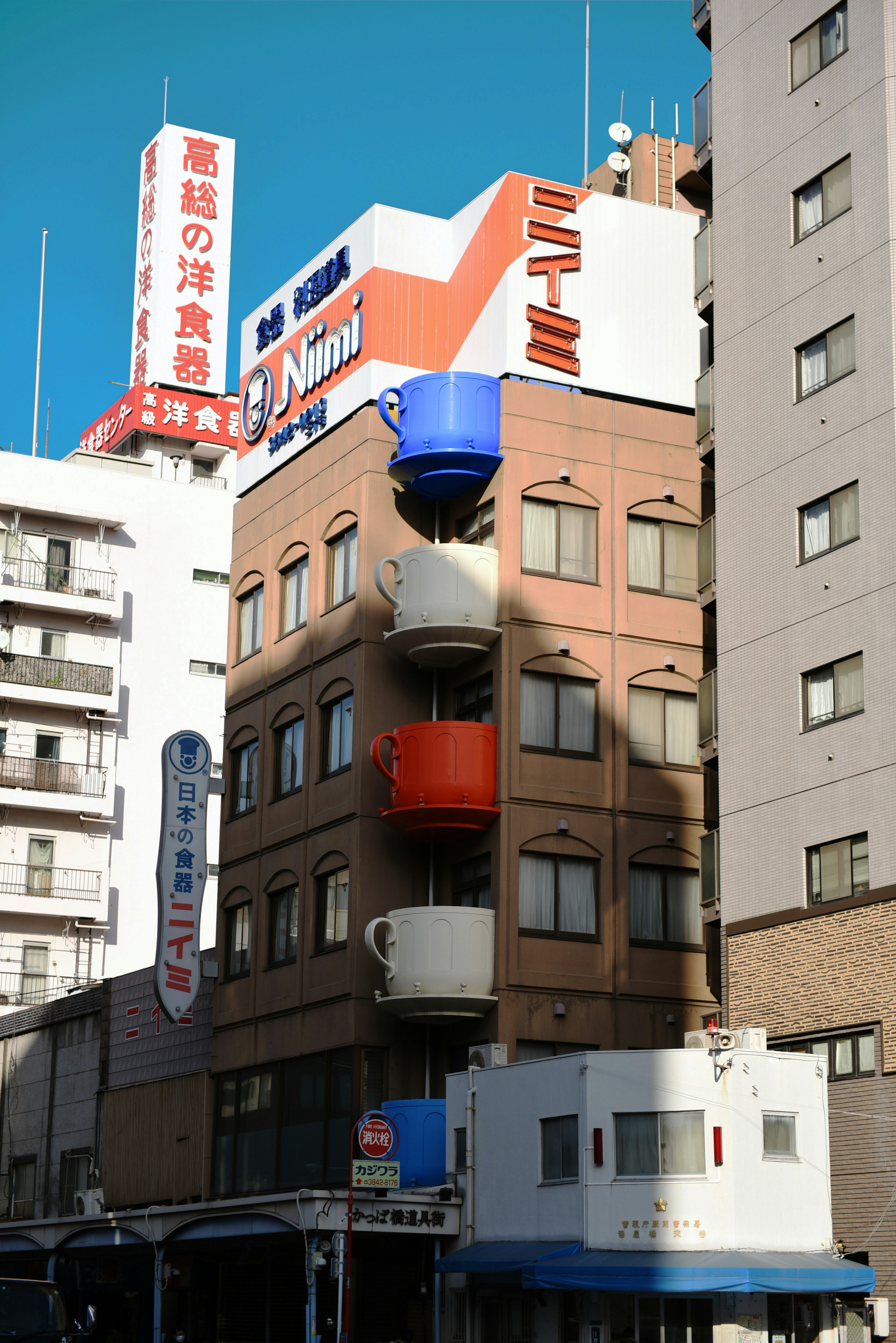 Extérieur d'un bâtiment avec des balcons en forme de tasses colorées