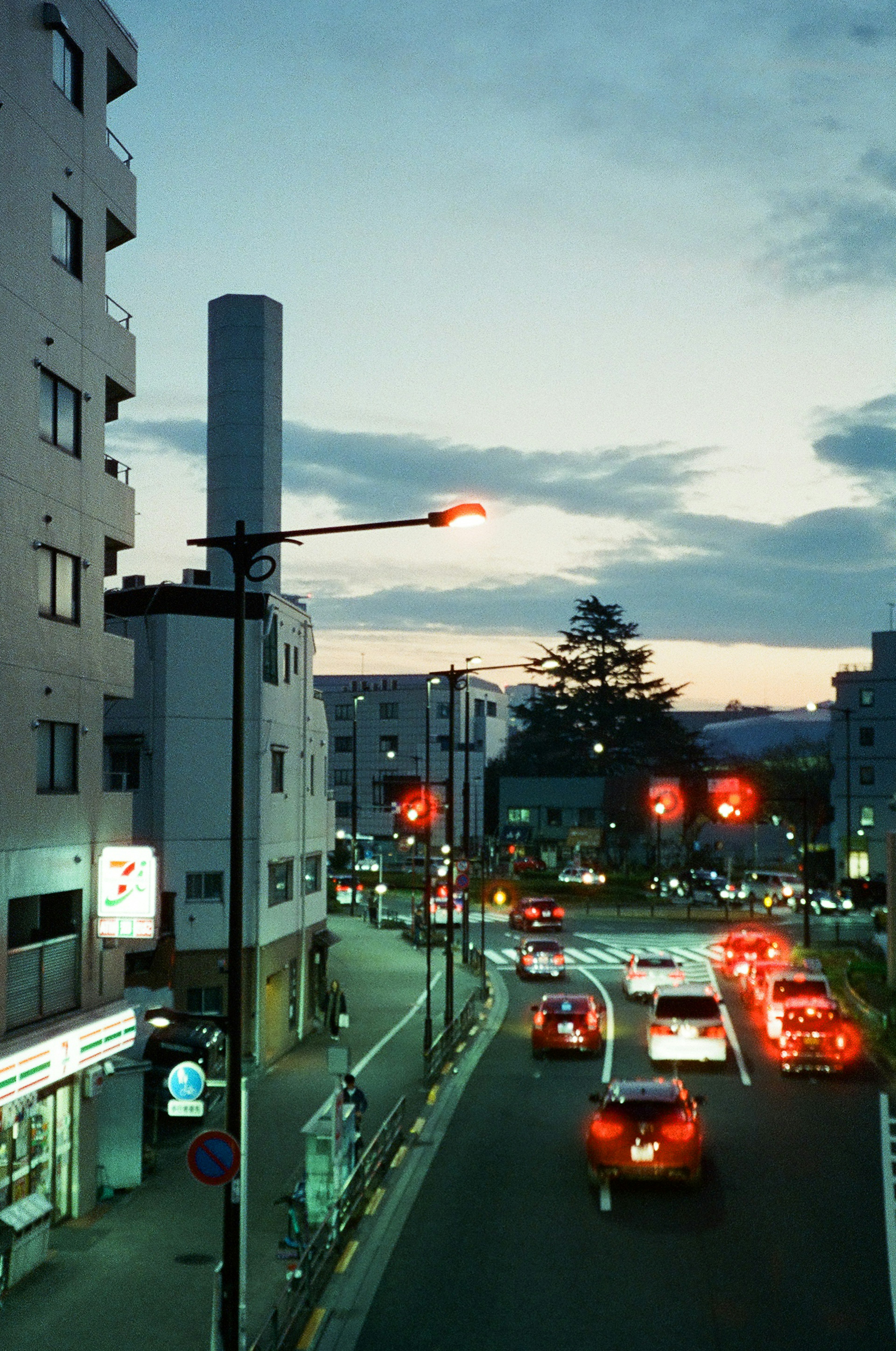 Scène d'intersection urbaine au crépuscule avec des feux rouges et des lampadaires