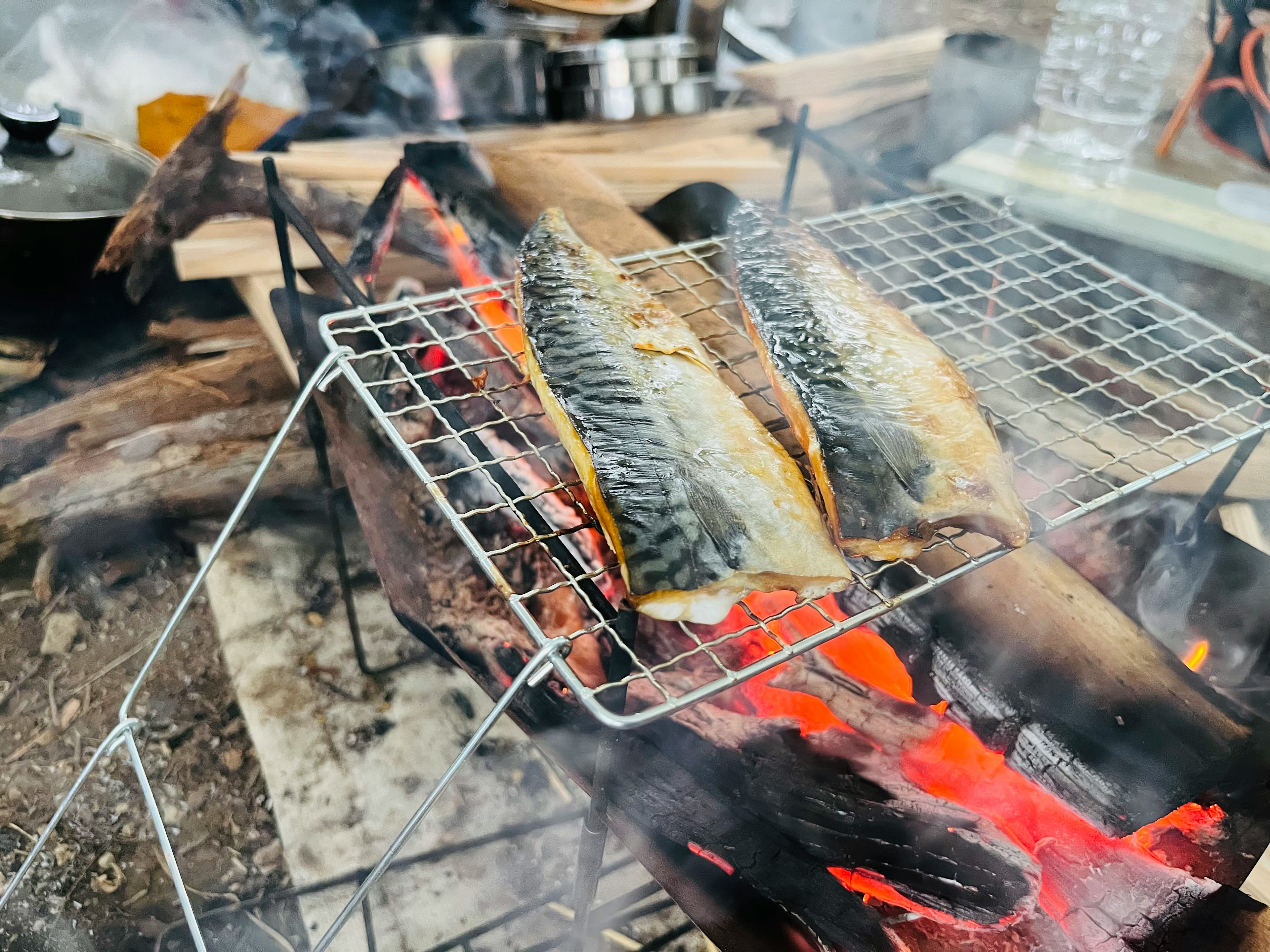 炭火で焼かれている魚のグリルの写真