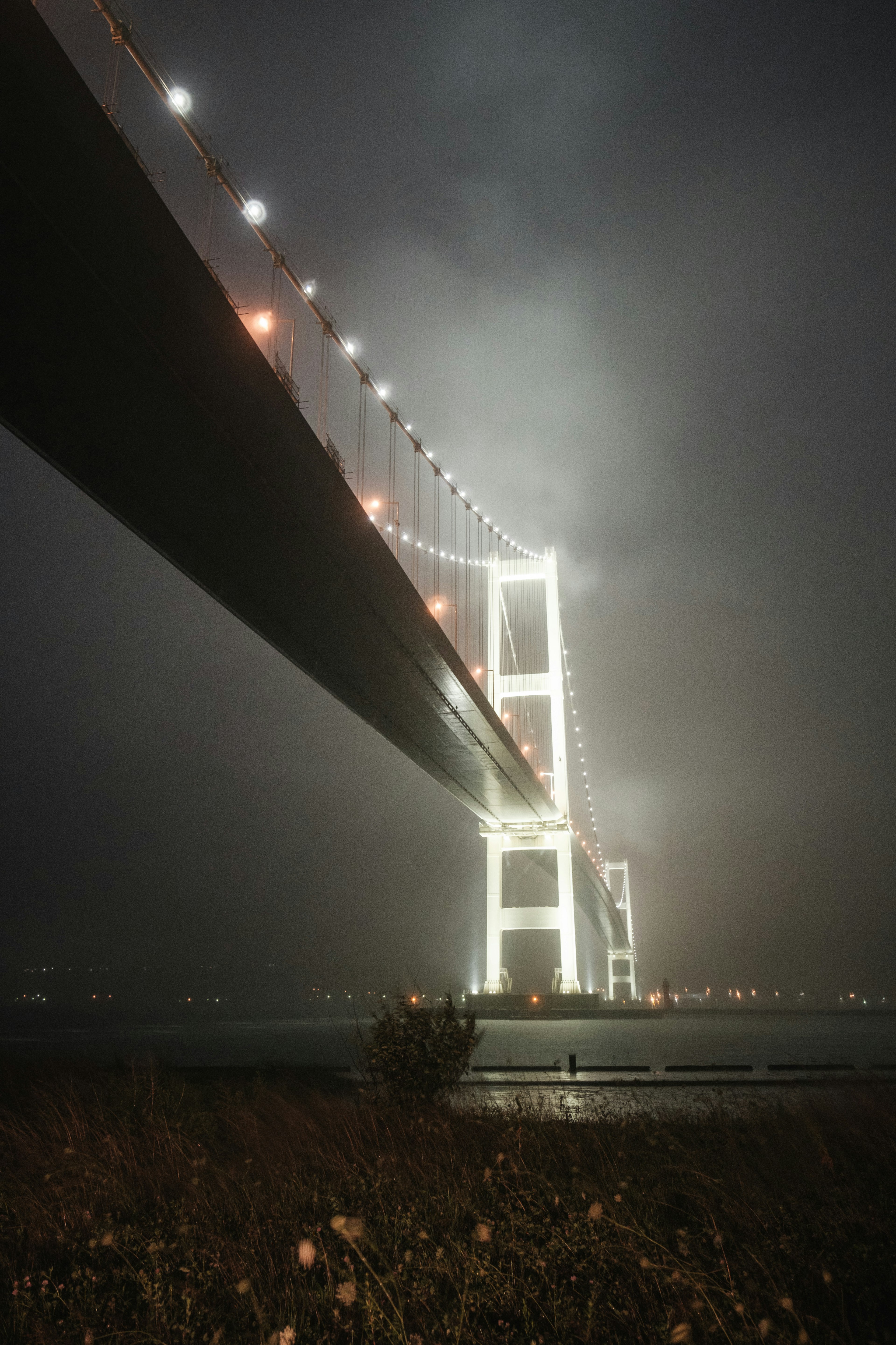 霧の中に浮かぶ美しい橋の夜景 明るい照明が際立つ