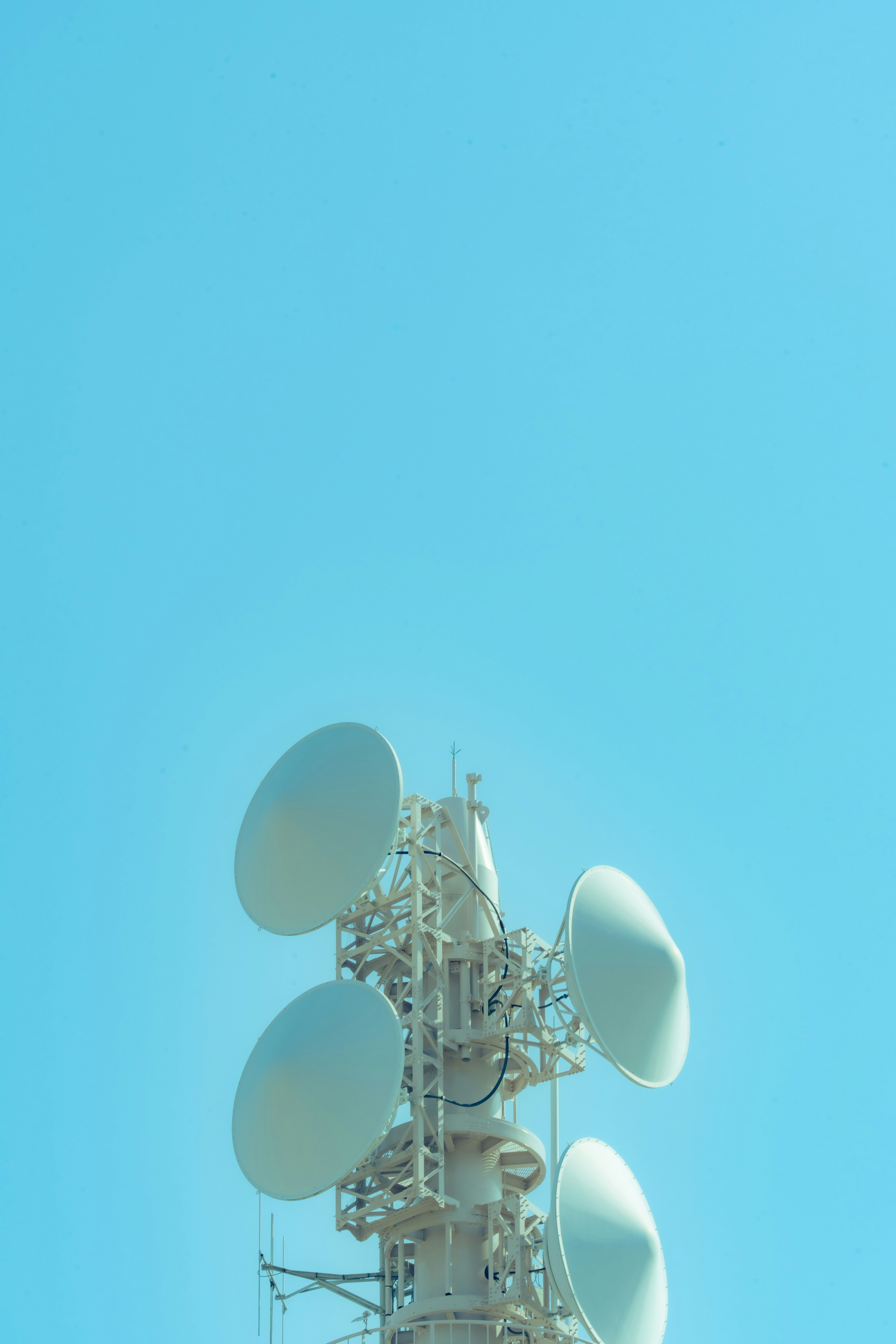 Tour de communication avec plusieurs antennes sur fond de ciel bleu