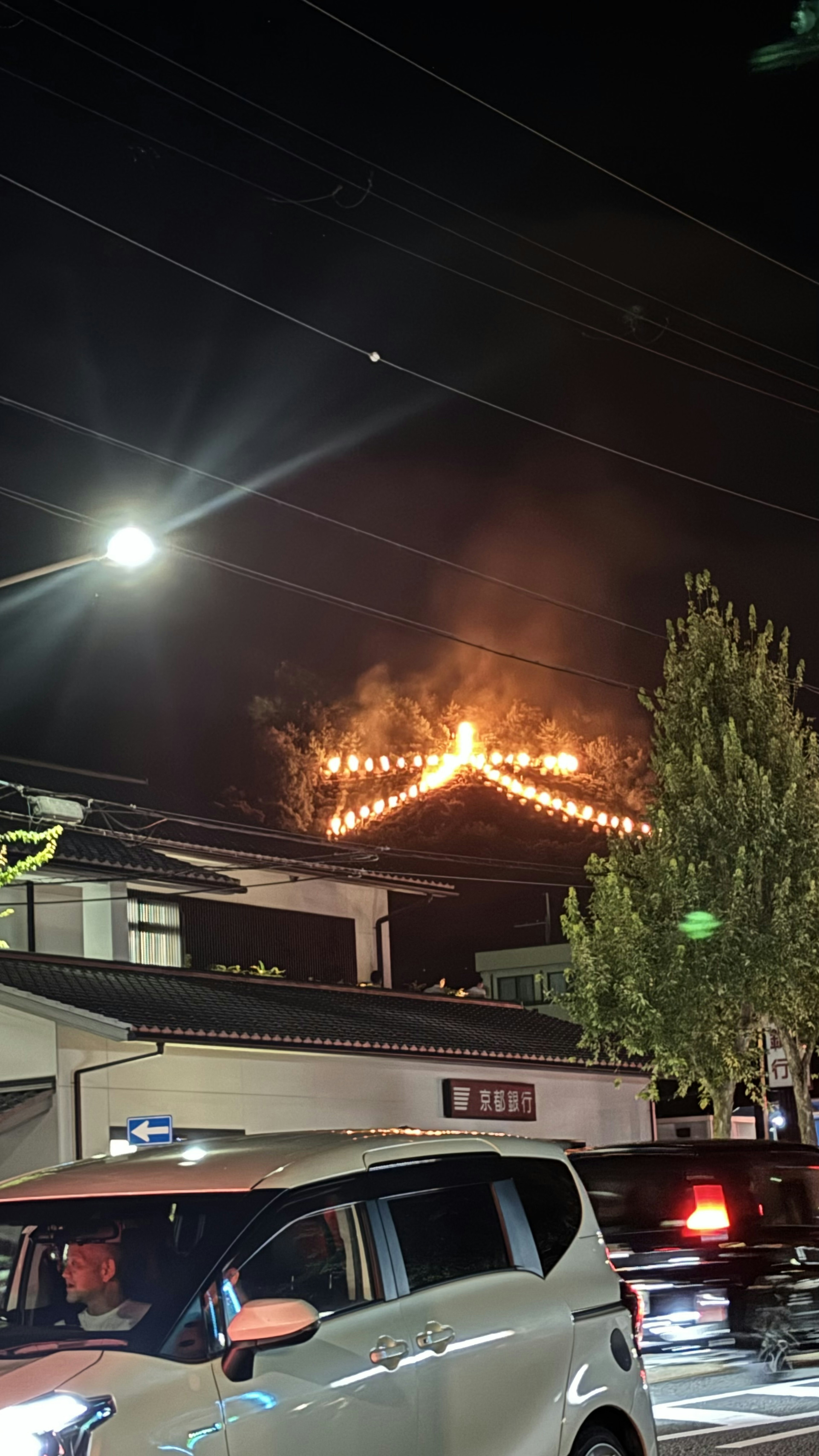 Vista nocturna de una calle con una decoración en llamas en forma de estrella