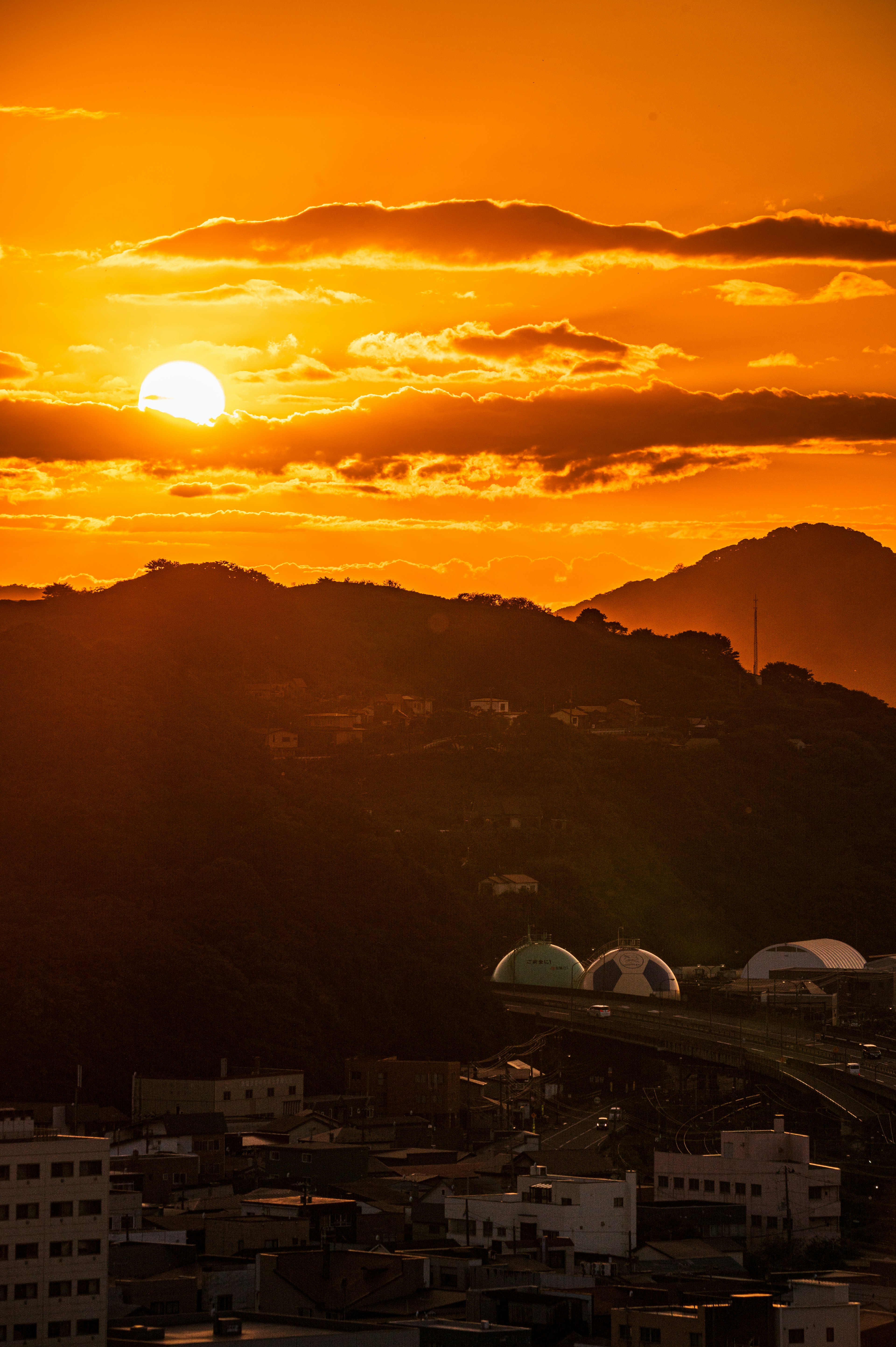 Pemandangan matahari terbenam yang indah di atas gunung dengan langit oranye