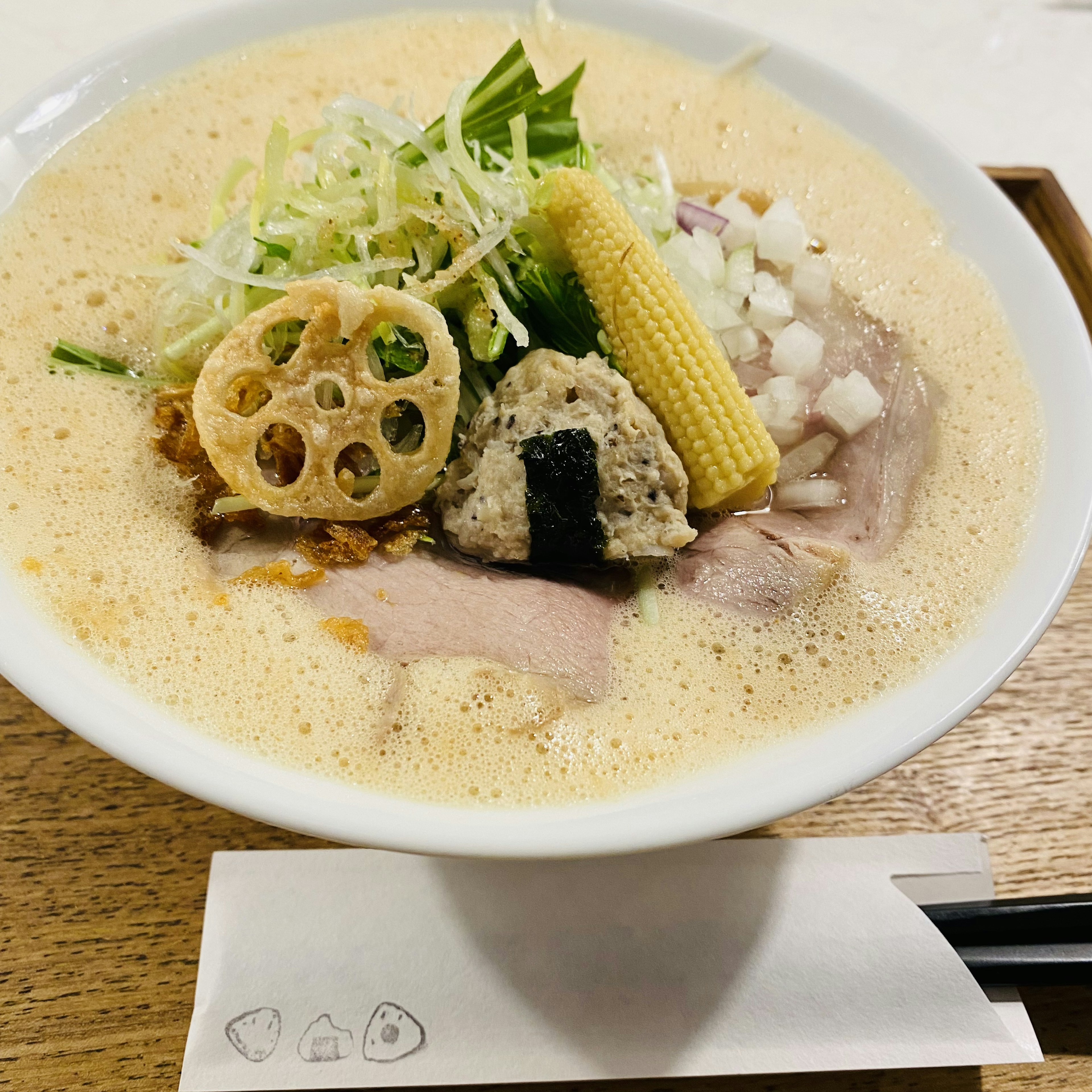 クリーミーなスープのラーメンに新鮮な野菜とトッピング