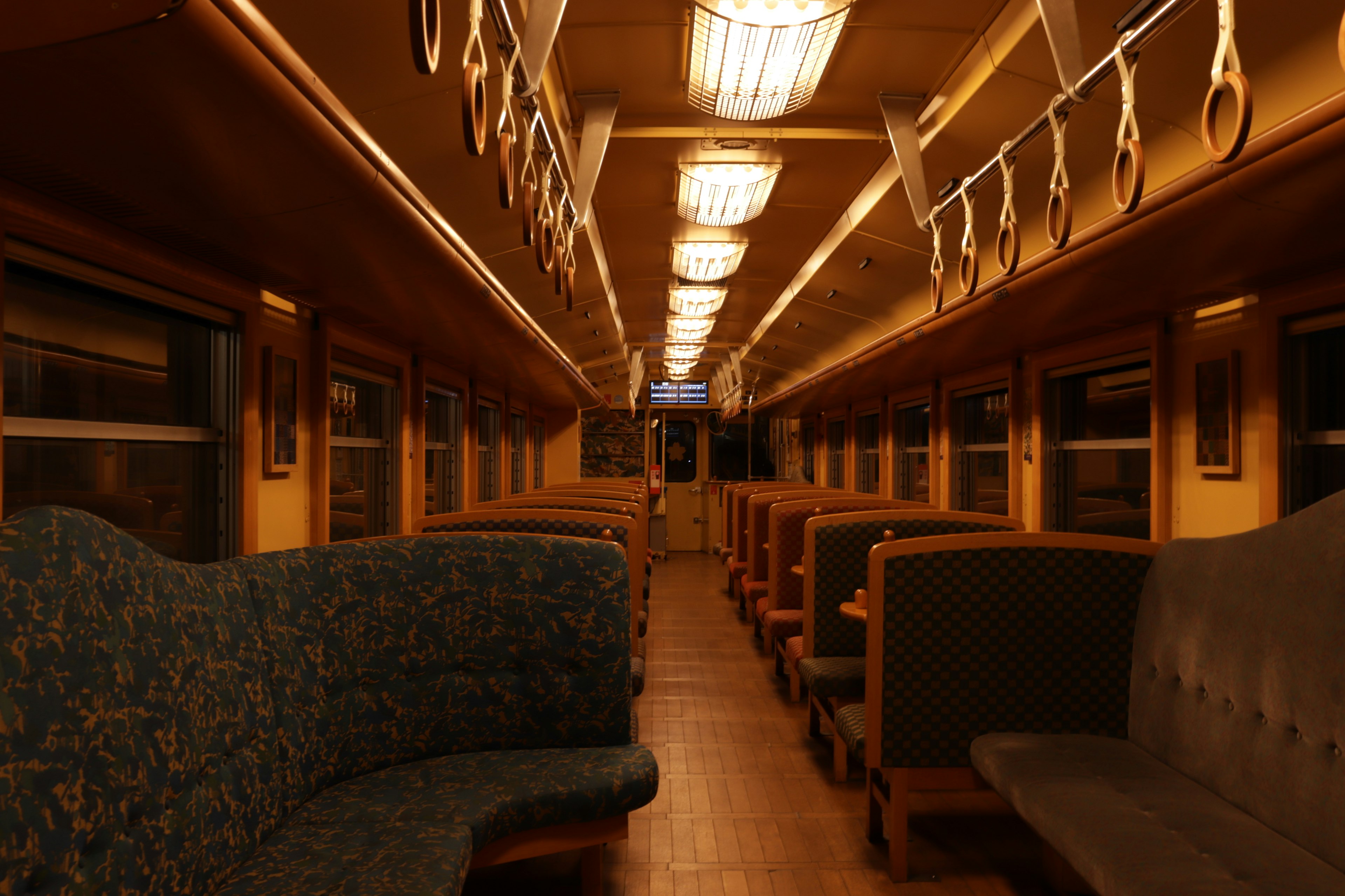 Interior of a train car featuring dim lighting and upholstered seats