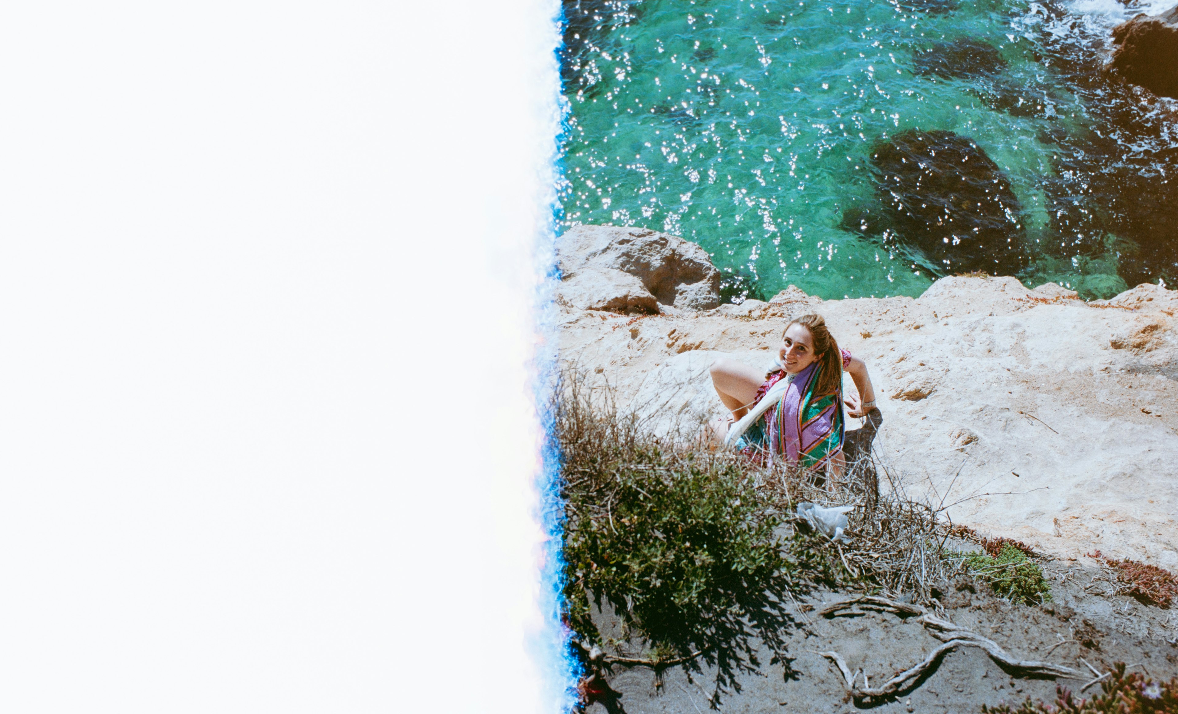 Une femme se relaxant sur la côte avec une belle mer bleue et un paysage rocheux